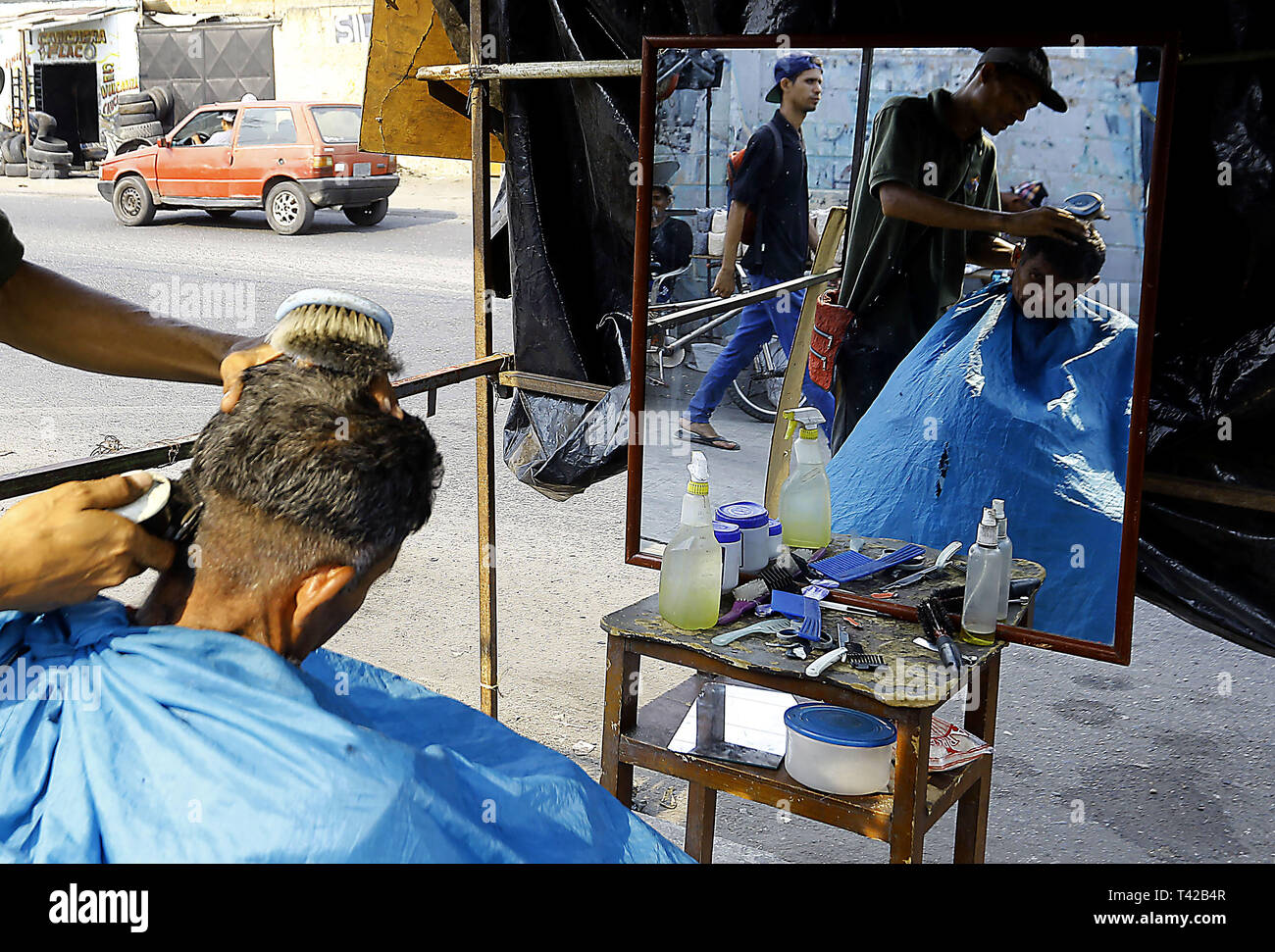 Valencia, Carabobo, Venezuela. 11 Apr, 2019. Pril 11, 2019. Gregory Hernandez, ist eine junge Venezolanische, die nicht mehr einen Job als Maurer, der seit vielen Jahren gewidmet war, beschlossen, eine lokale Straße, zu improvisieren und der Friseur- Service an solicarios Preise anbieten, die nach seinen eigenen Worten mindestens hilft Essen für Ihre Familie erhalten. Akzeptiert abgesehen von Bargeld oder elektronisches Geld, Pakete von Reis, Brot, Mehl, Teigwaren und anderen Lebensmitteln. Das Foto wurde auf Arantzasu Avenue, südlich der Stadt Valencia, Carabobo Zustand. Foto: Juan Carlos Hernandez (Credit Bild: © Juan Carlos Stockfoto