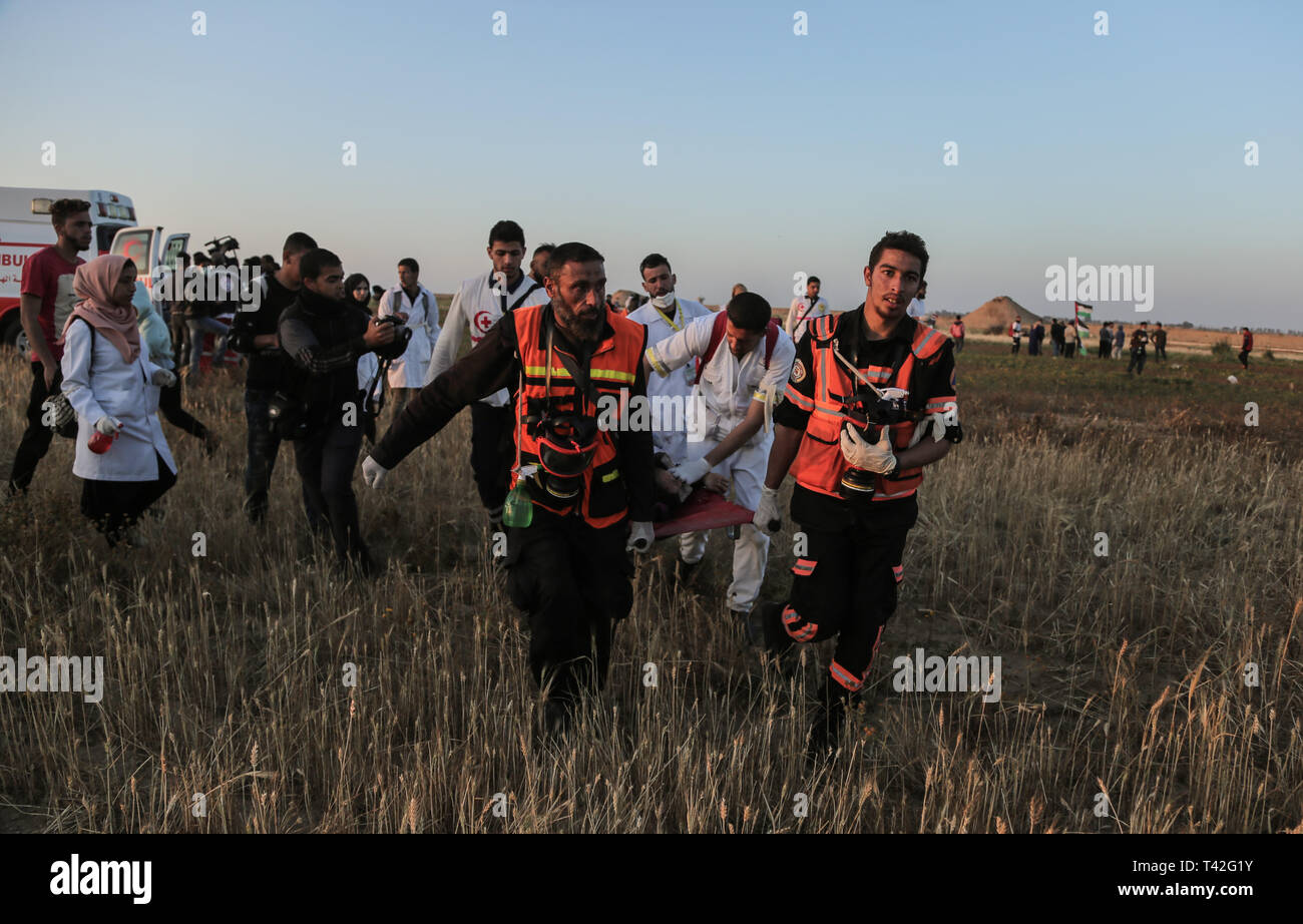 Palästinensische Sanitäter werden gesehen, die eine verletzte Demonstrant während der Demonstration in der Nähe der Grenze zu Israel, östlich von Khan Yunis im südlichen Gazastreifen. Ein palästinensischer Jugendlicher erschossen wurde durch die israelische Armee während der erneuten Auseinandersetzungen auf der Grenze zum Gazastreifen, das Gesundheitsministerium in den palästinensischen Enklave, sagte ein Ministeriumssprecher sagte Abu Shaloof Maysara, 15, ist heiß im Magen wurde durch die (Israelische) Besatzung östlich von Jabalia, die sich zu einer Demonstration Site im nördlichen Gaza-Streifen. Stockfoto