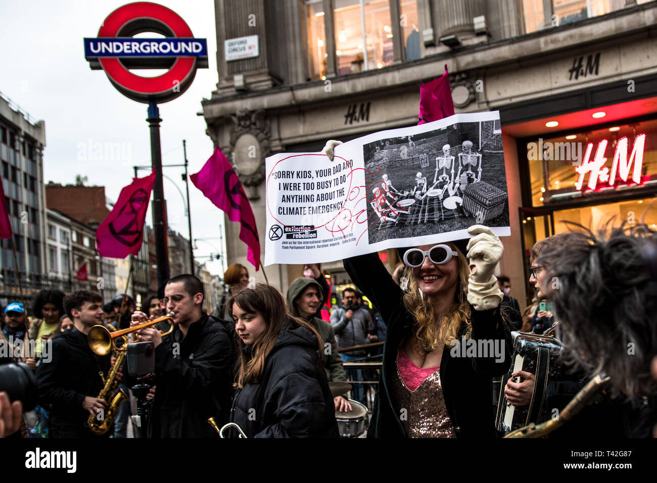 London, Großbritannien. 12 Apr, 2019. Eine Frau Aktivist gesehen halten ein Banner während der Veranstaltung. Das Aussterben Rebellion Mode Action Group brachten Oxford Circus zum Stillstand durch die Inszenierung eine kreative und symbolische catwalk Titel Mode: Zirkus der Selbstbeteiligung. Ziel ist es, den Alarm über die Rolle der Mode Konsum spielt in der Klima- und Ökologische Not zu erhöhen. Die Modeindustrie ist ein Viertel der weltweit CO2-Budget 2050 in Bekleidung Produktion zu verbrauchen. Credit: SOPA Images Limited/Alamy leben Nachrichten Stockfoto