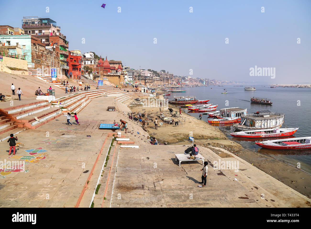 Luftbild des Ganges in Varanasi mit antiken Architektur, Holz- boote und Kinder spielen und Drachen steigen Stockfoto