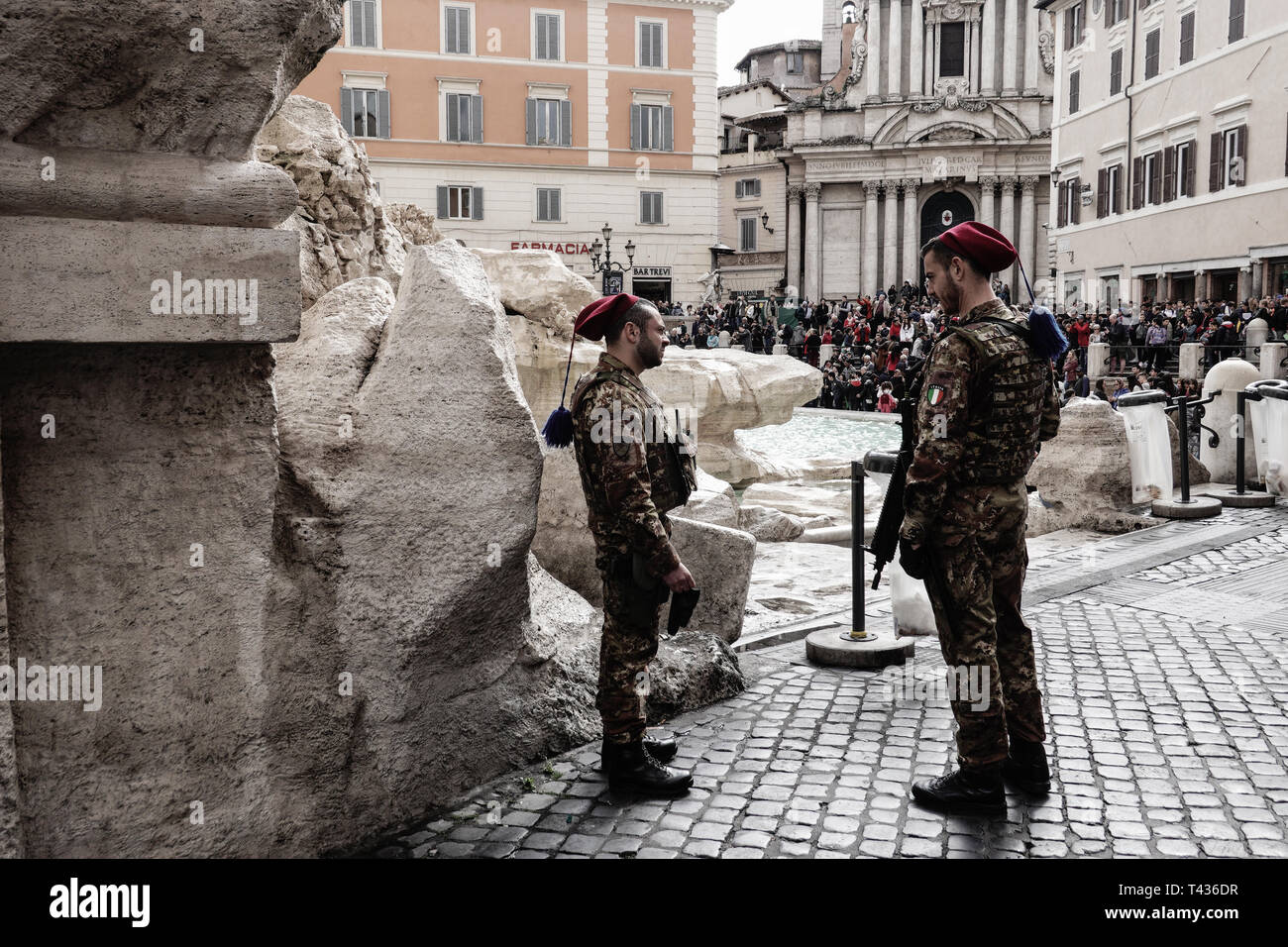 Soldaten sichern den Trevi Brunnen, die Fontana di Trevi, als Tausende von Touristen strömen in die Stadt Rom. Paare von bewaffneten Soldaten im Kampf Uniformen sind e Stockfoto