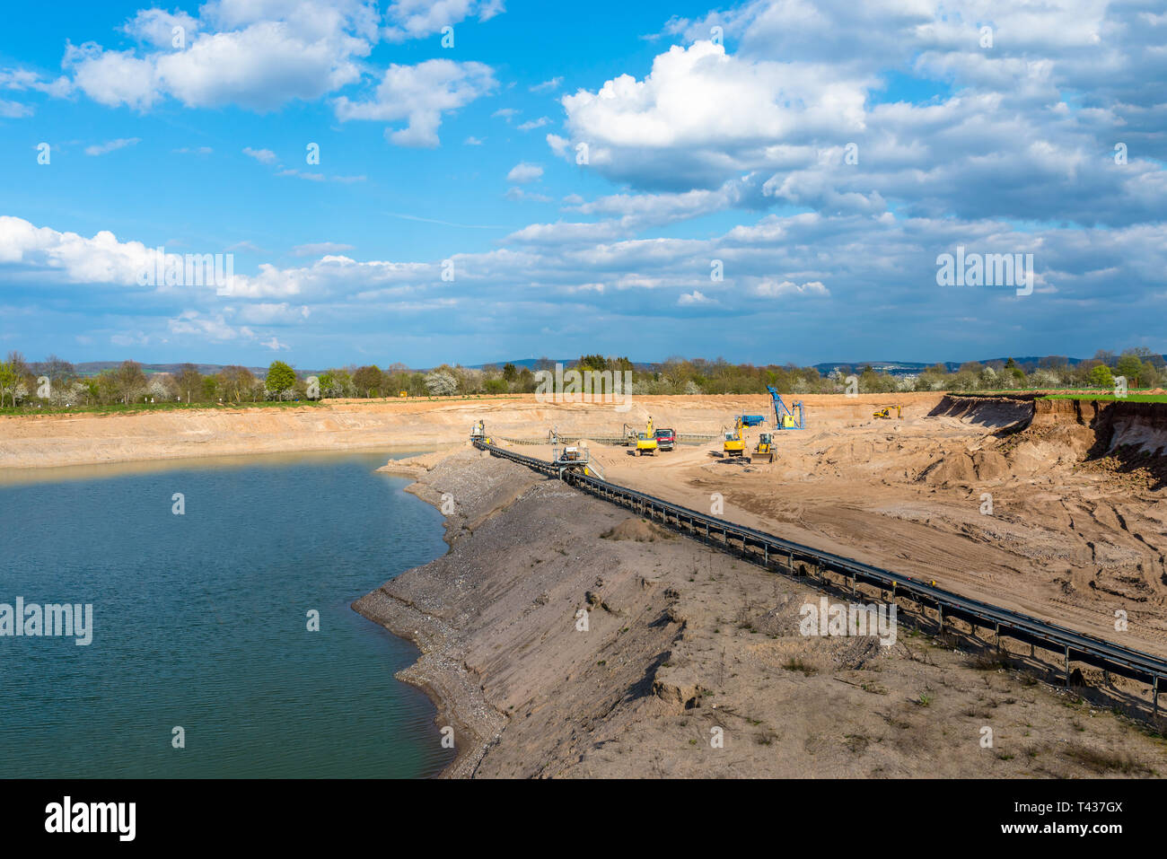 Eine Zeichenfolge, die der Verkehr in einer Kiesgrube Treibriemen für den Transport von Kies und Sand über lange Entfernungen, Gürtel weiter am See entlang. Stockfoto