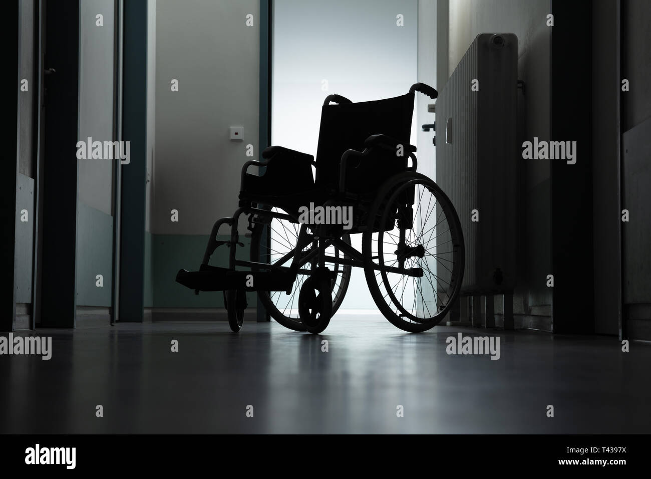 Silhouette von leeren Rollstuhl geparkt im Krankenhaus Flur Stockfoto