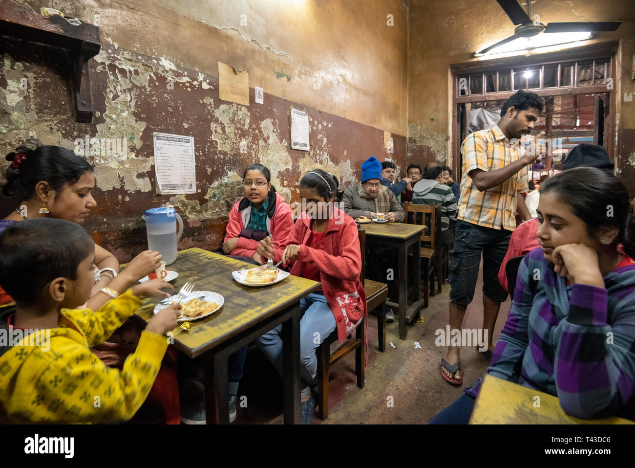 Horizontale Ansicht Lokale Leute in einem ramshackled Restaurant in Kalkutta aka Kalkutta, Indien zu essen. Stockfoto