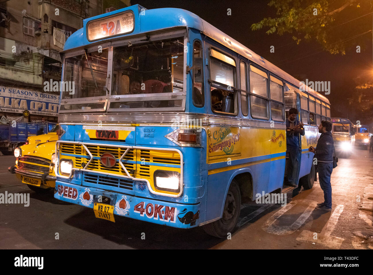 Horizontale Sicht auf einen öffentlichen Bus hinunter die Straße in Kalkutta aka Kalkutta, Indien fahren. Stockfoto