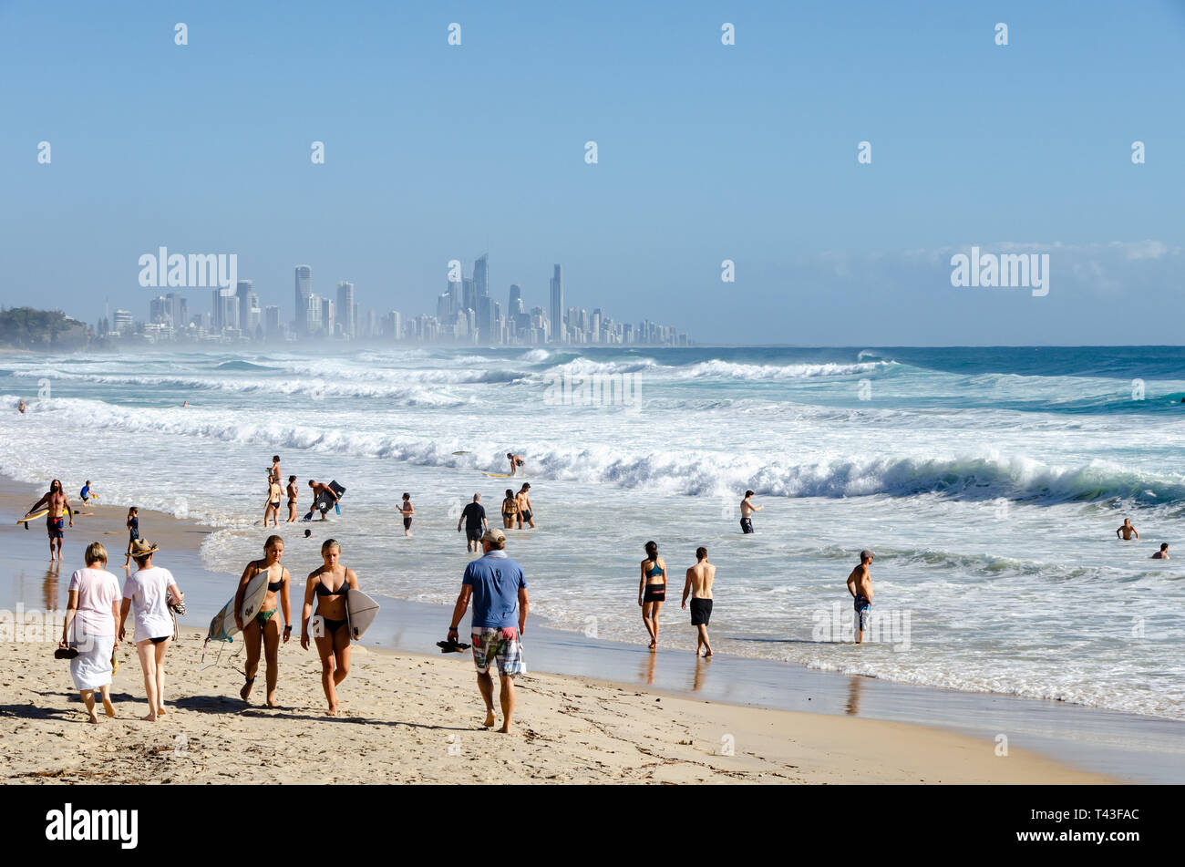 Die Leute am Strand, Schwimmen und Surfen, bei Burleigh Heads, Gold Coast, Queensland, Australien. Surfers Paradise in Distanz. Stockfoto