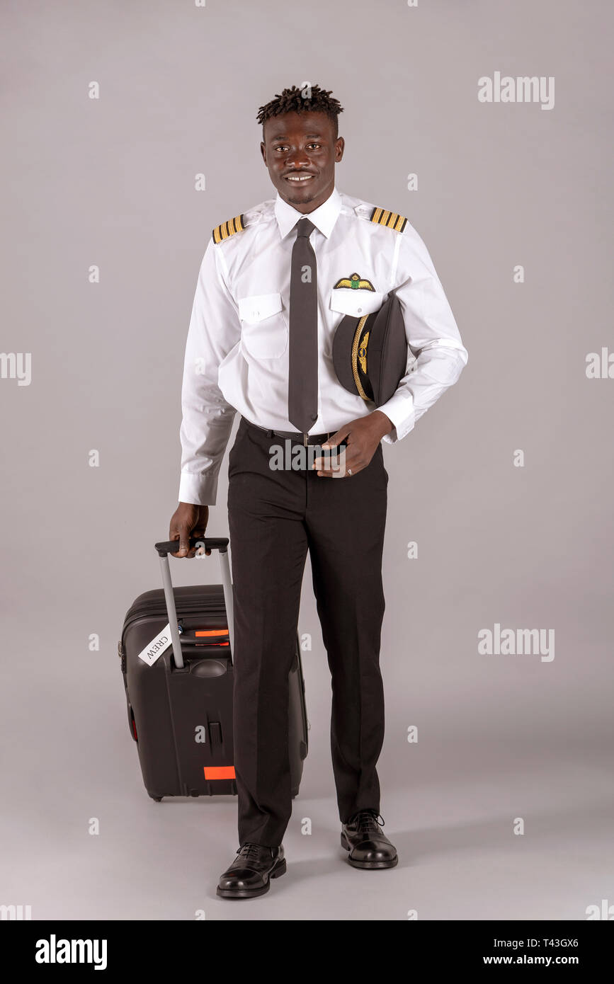 April 2019. Ein junger Pilot mit einem afrikanischen dred Frisur und Flight Bag auf Rädern. Stockfoto