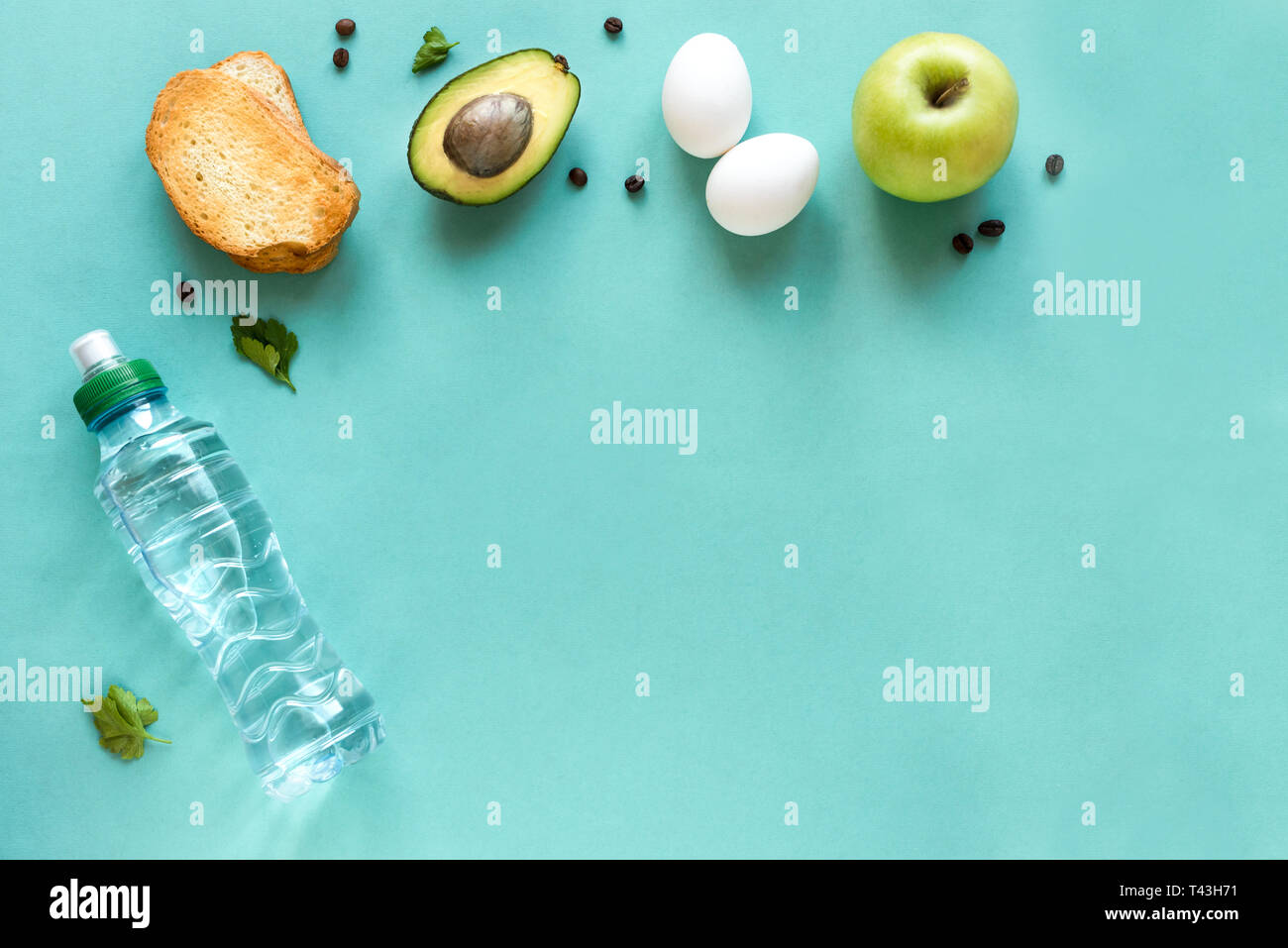 Avocado, Ei und Toast zum Frühstück und Wasser auf blauem Hintergrund, Ansicht von oben, kopieren. Gesunde Zutaten für das Frühstück - Eier, Brot, Avocado und Kaffee Stockfoto