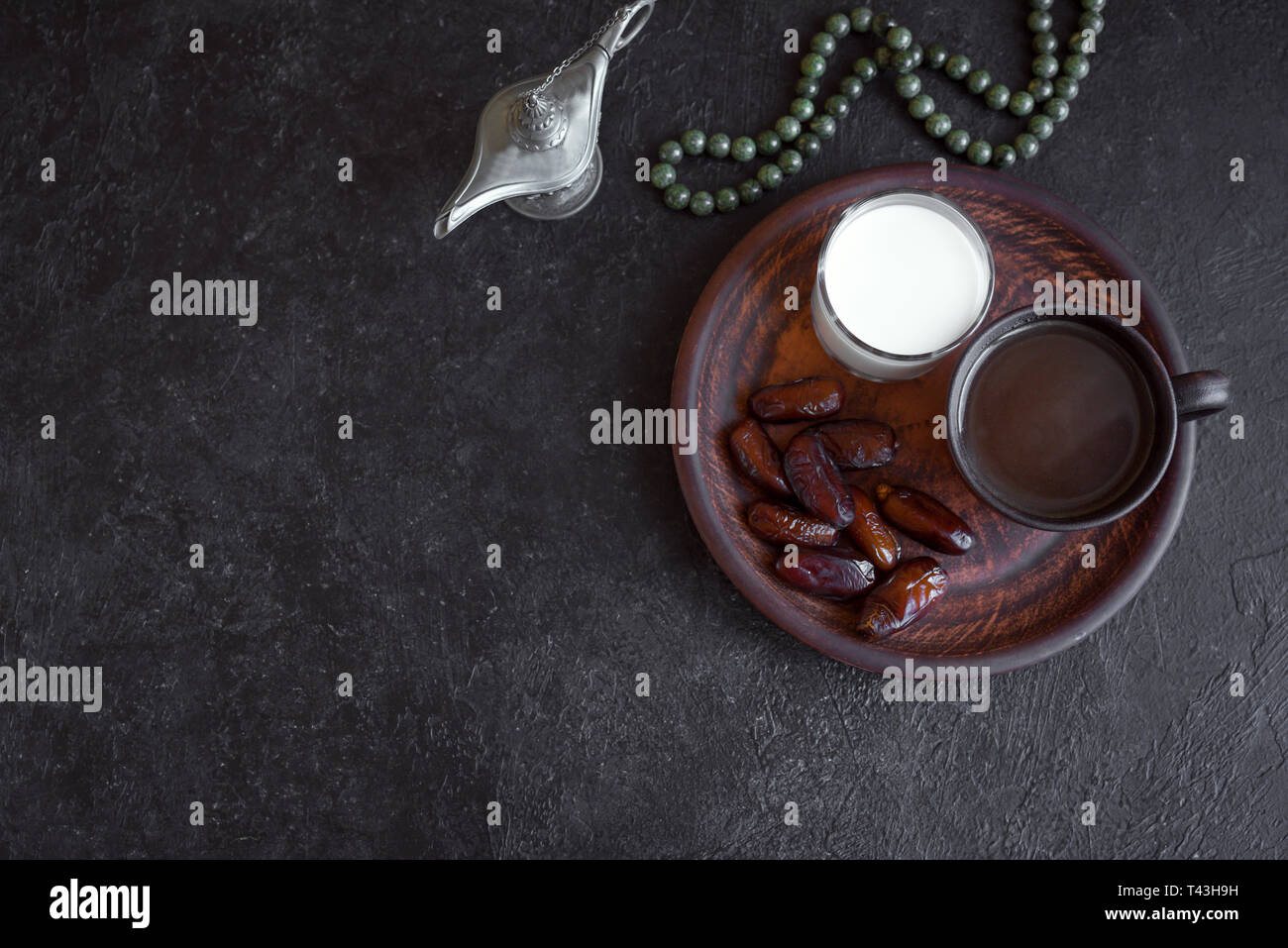 Traditionelle muslimische Iftar Essen auf Schwarz, kopieren. Ramadan Kareem mit Terminen, Milch und Kaffee. Ramadan iftar Essen Konzept mit Rosenkranz. Stockfoto