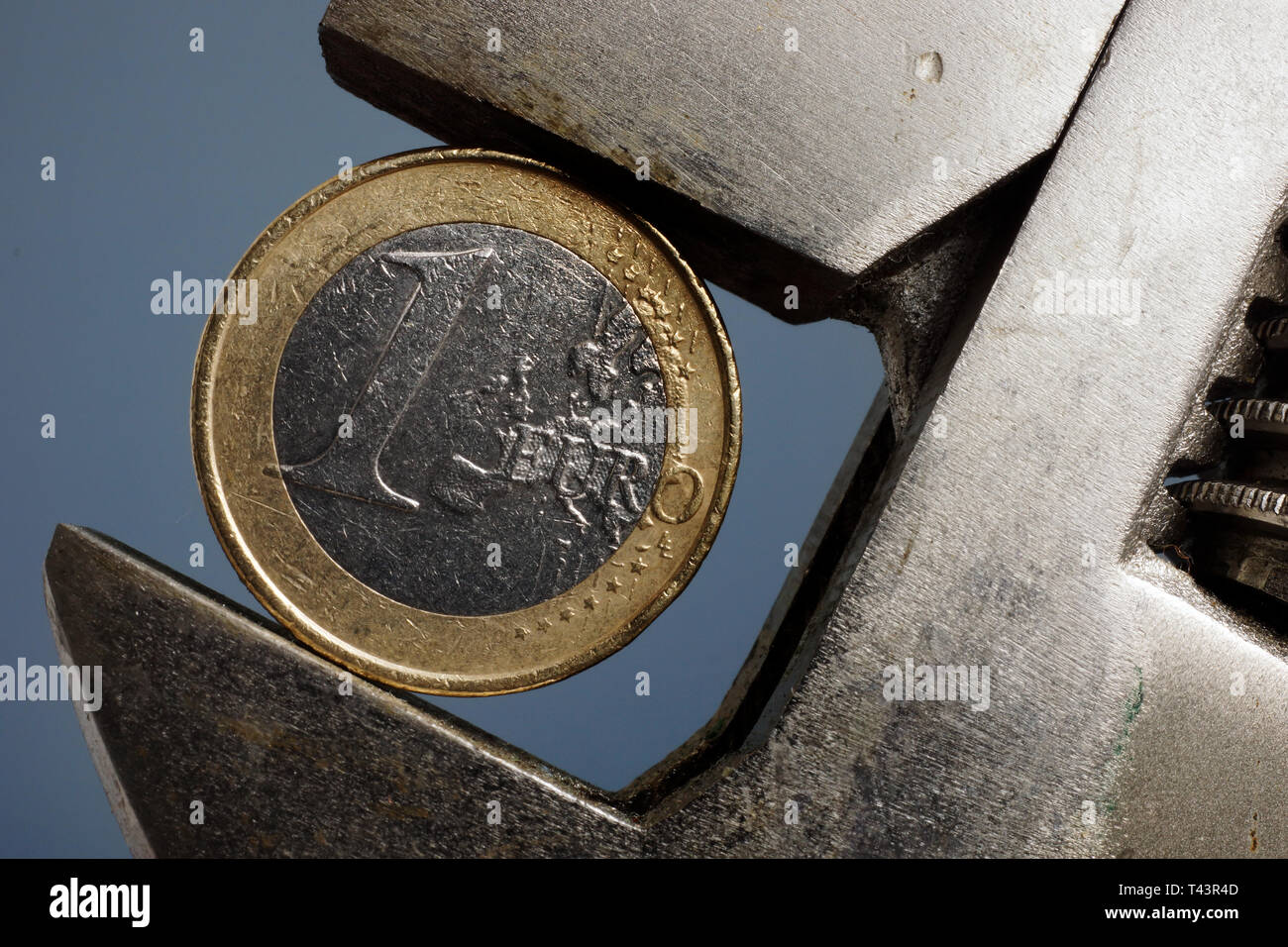 Euro Münze Zange zusammengedrückt. Finanzkrise und die Inflation in Europa Konzept. Stockfoto