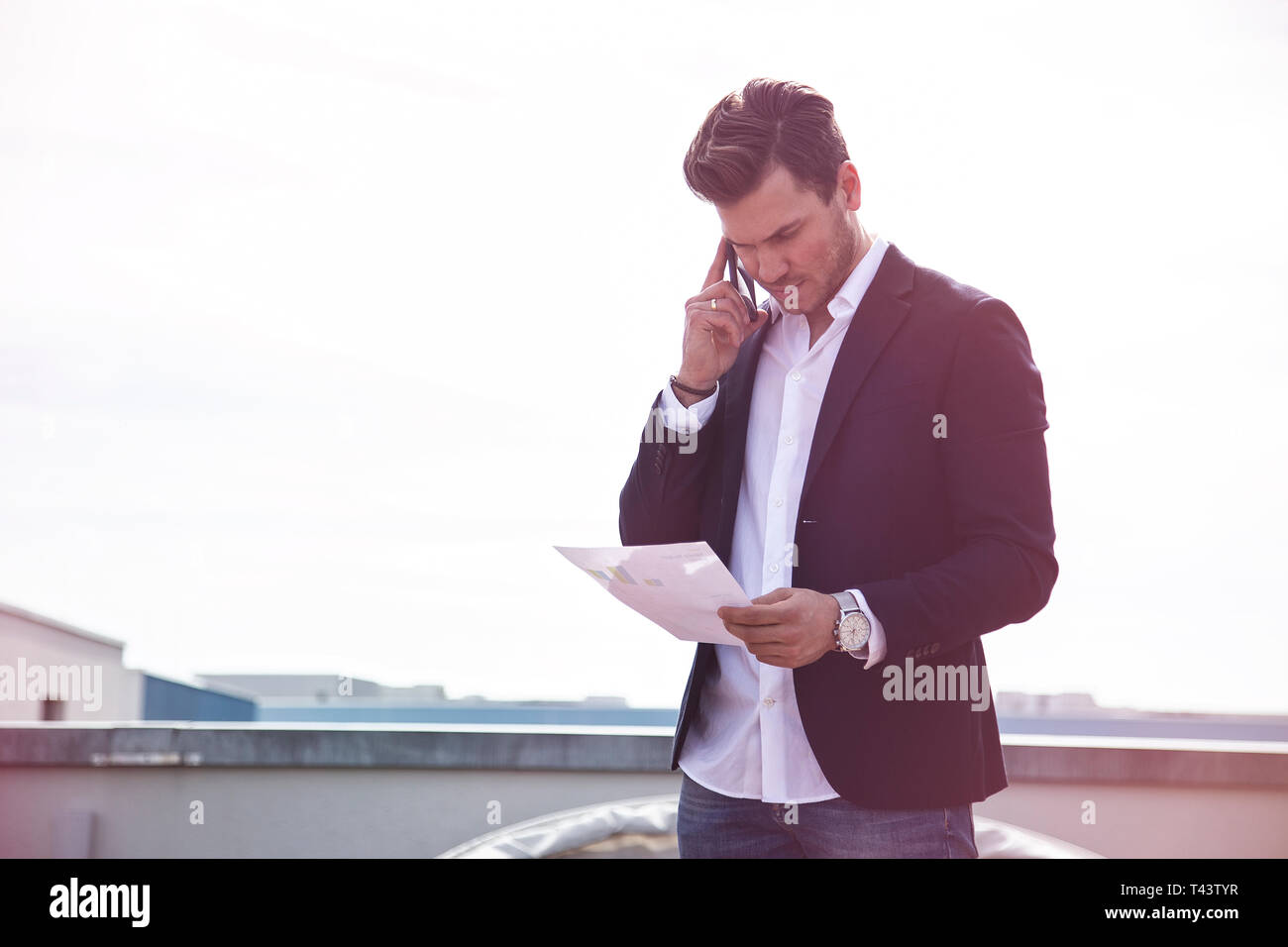 Schöne charmante junge Erwachsene Geschäftsmann Texteingabe auf Smartphones im Freien Stockfoto