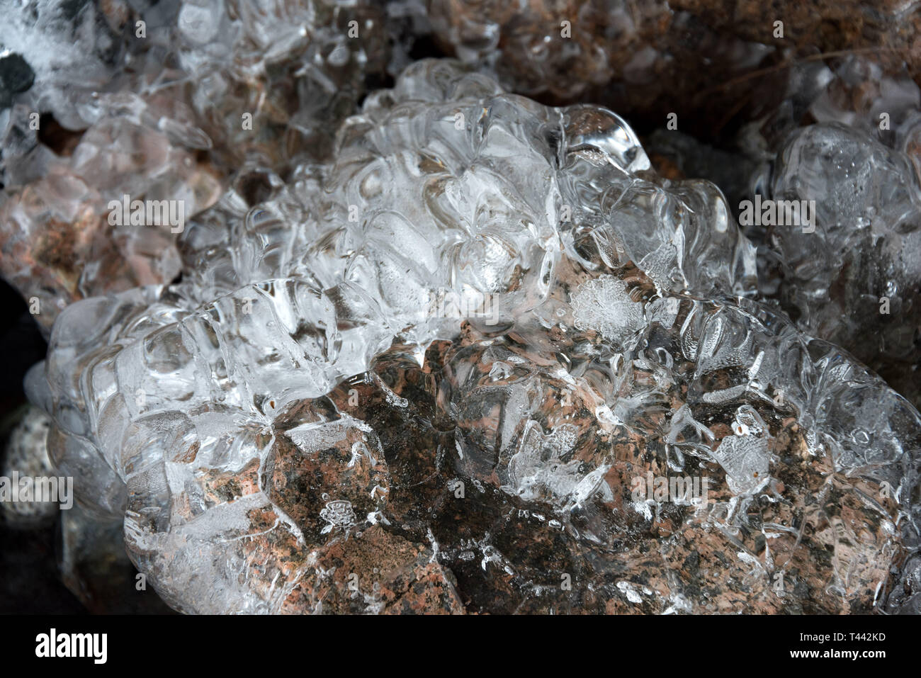 Ungewöhnliche Eisformationen unter tropfenden Eiszapfen. Stockfoto