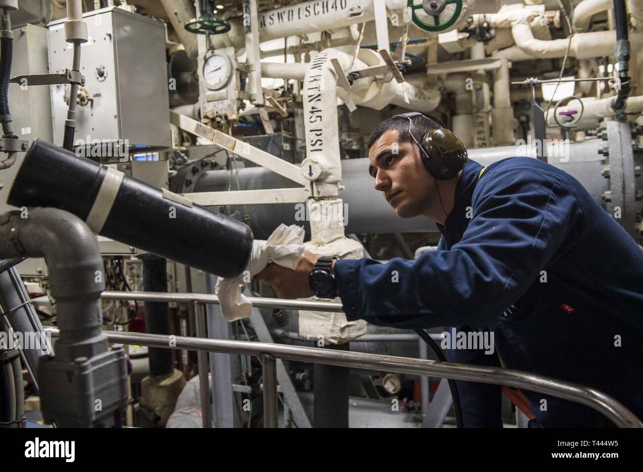 Philippinischen MEER (16. März 2019) in der 2. Klasse Engineman Anthony Castillo hält einen Feuerlöscher wie er Schlachten einer simulierten Klasse bravo Brand engineering Training drill an Bord der Rächer - Klasse meine Gegenmaßnahmen Schiff USS Pioneer (MCM 9). Pionier, Teil der Mine Countermeasure Squadron 7, ist die in den USA 7 Flotte Einsatzgebiet Interoperabilität mit Partnern zu verbessern und dienen als eine fertige Antwort Plattform für Blindbewerbungen. Stockfoto