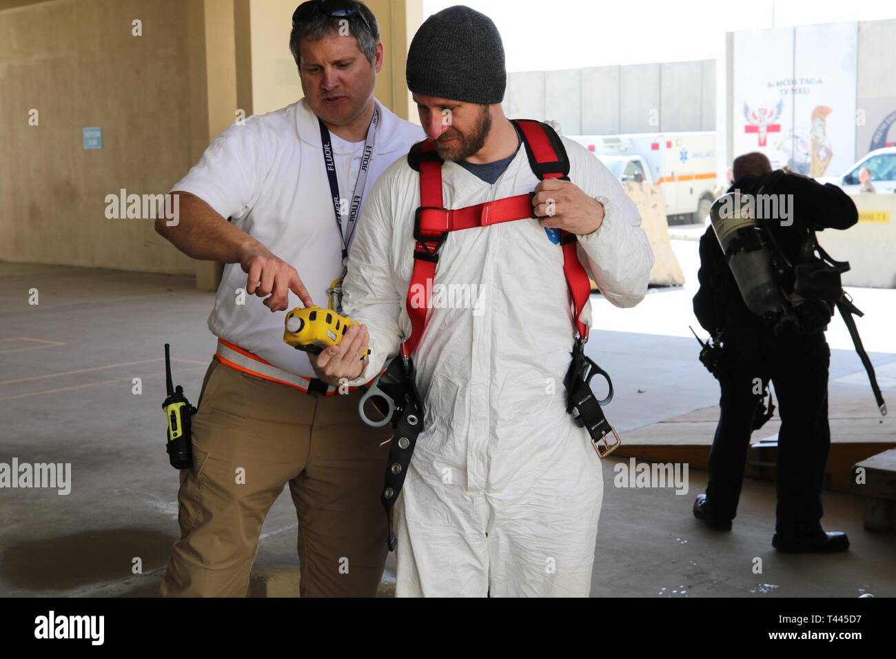 David Lynne, den Area Support Group-Afghanistan und George Parker, Mehl Feuerwehr Messwerte von einem mobilen WLAN-multi-diskutieren. Die bagram Feuerwehr laufenden, kontinuierlichen Überwachung der Verbrennung Gefahr, Sauerstoff, Kohlenmonoxid und andere giftige Gase sowie Emergency First Response und Extraktion. Stockfoto