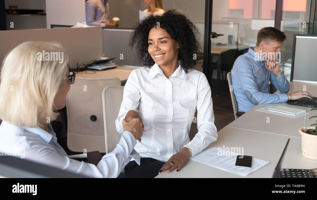 Lächelnden jungen afrikanischen Mitarbeiter client Handshake alten Business Manager Mentor Stockfoto