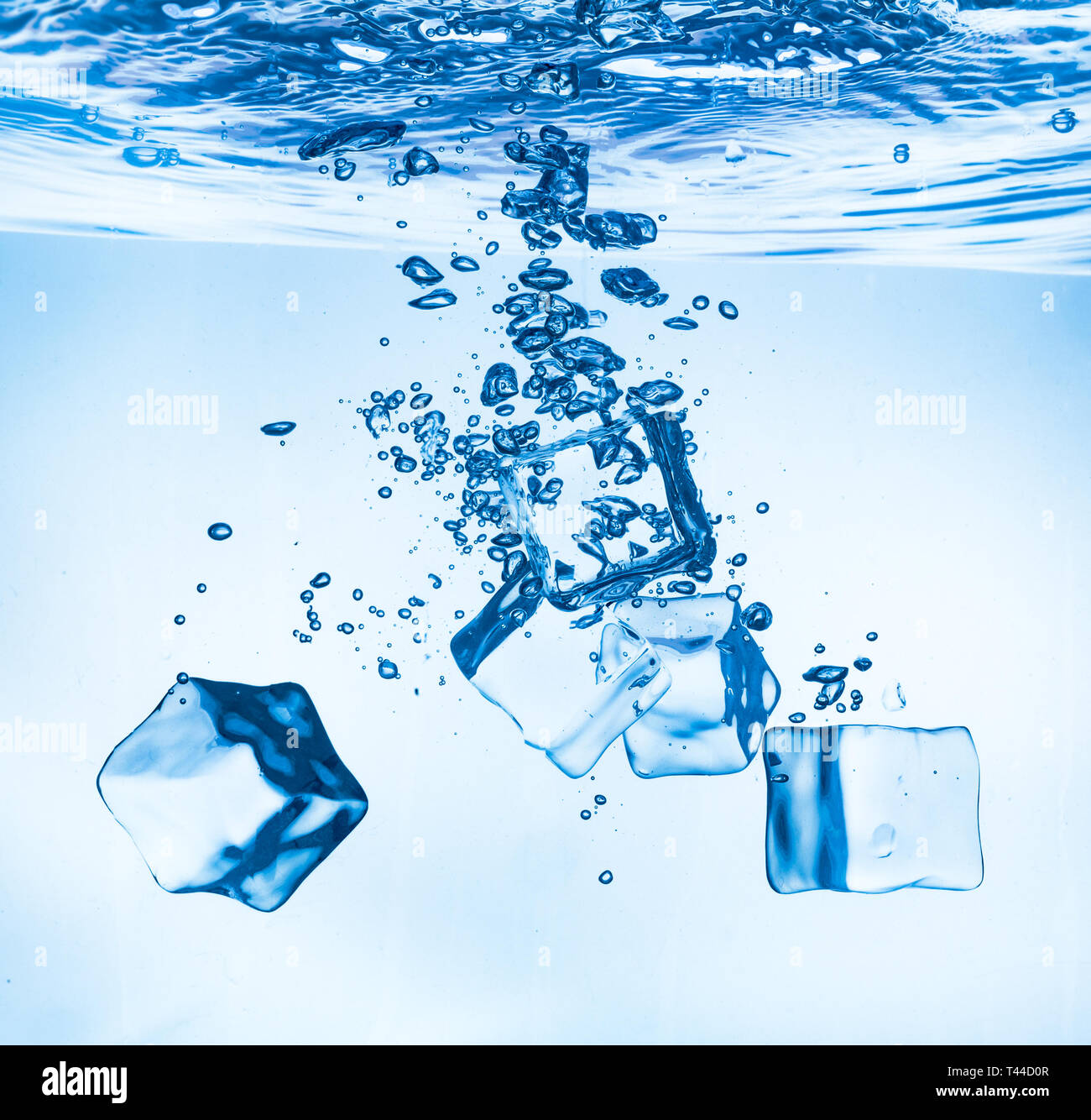 Eiswürfel ins Wasser sinken auf den Boden zu fallen. Zusammenfassung Hintergrund. Stockfoto