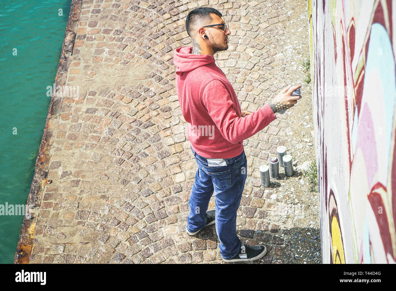 Street Graffiti Künstler Malen mit einem Color Spray kann ein Graffiti Wandbild an der Wand - Urban, Lifestyle, Street Art Konzept Stockfoto
