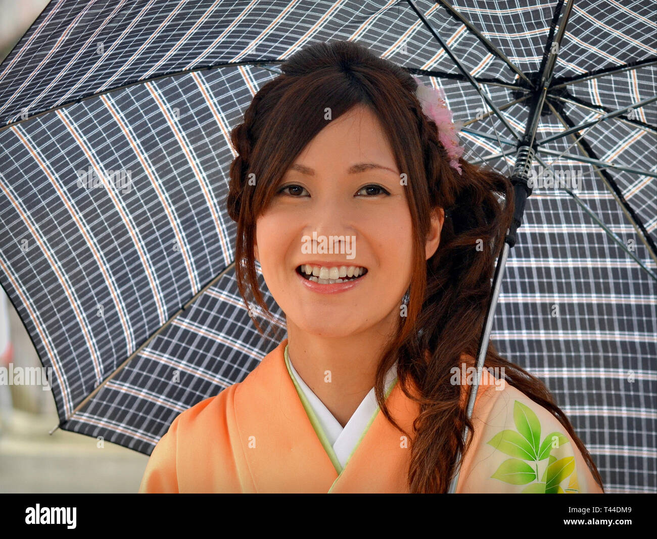 Schönen, jungen japanischen Frau wirft unter ihrem Dach an einem regnerischen Tag. Stockfoto