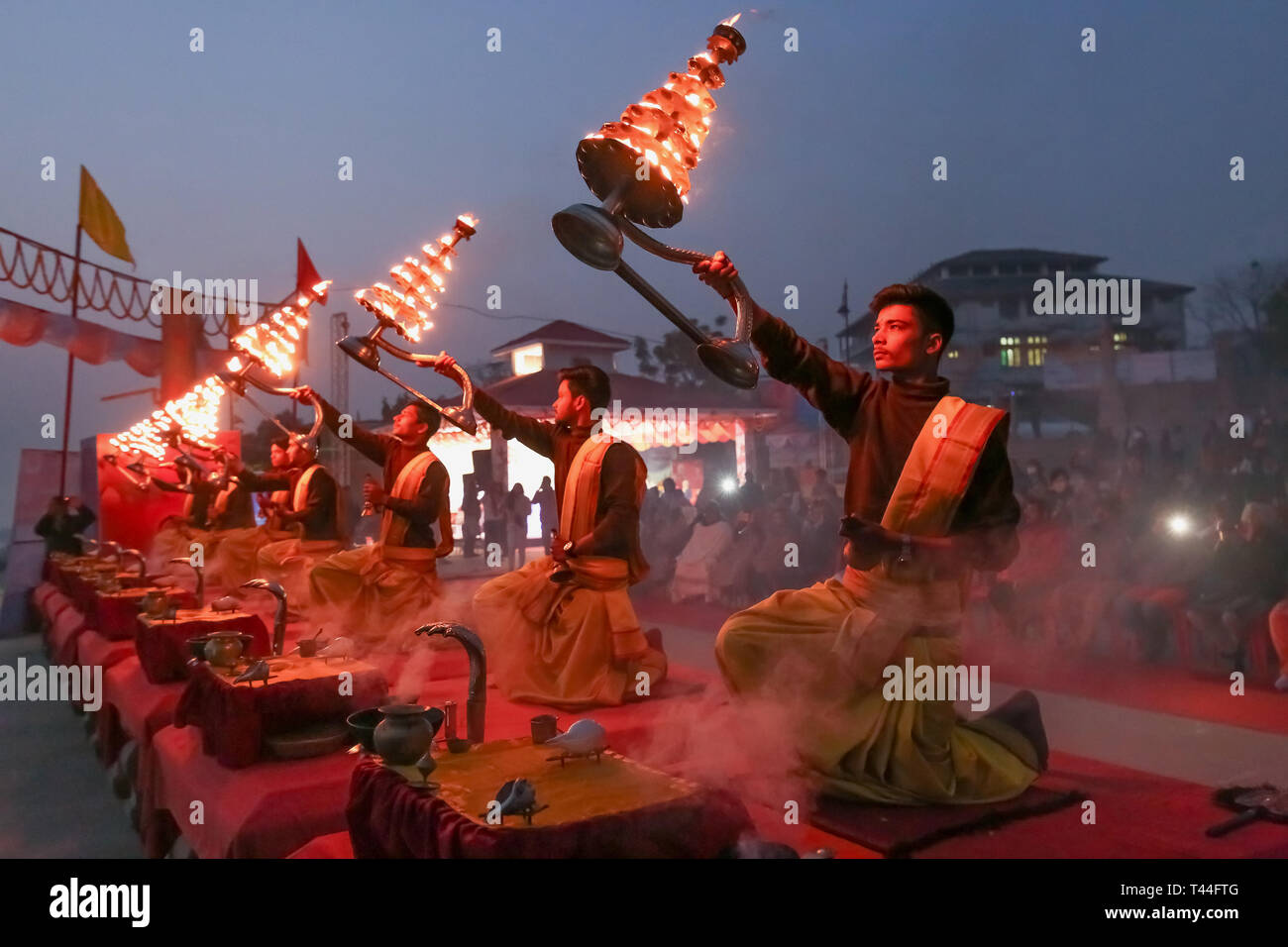 Jungen Hindu Priester führen traditionelle Ganga Aarti Zeremonie Rituale mit Feuer vor Sonnenaufgang auf dem Ganges in Varanasi, Indien. Stockfoto