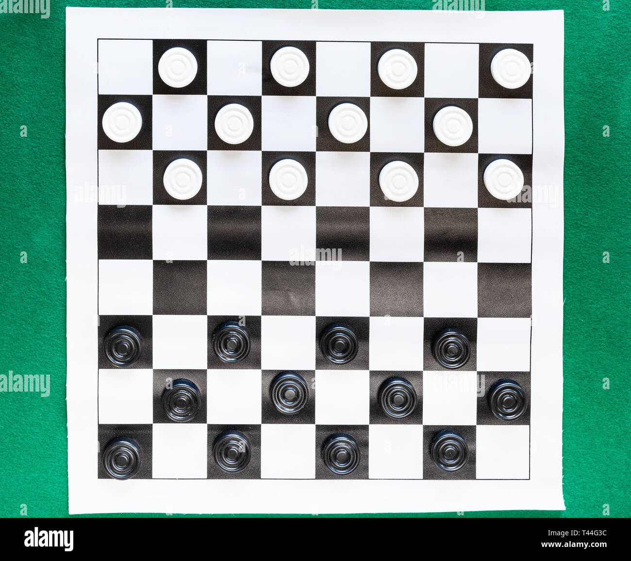 Blick von oben auf die Entwürfe auf schwarz-weiß karierten Blatt Board auf grünem Filz Tisch Stockfoto
