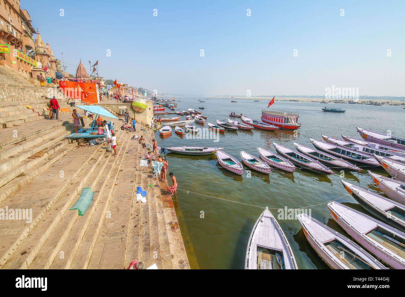 Blick auf den Ganges in Varanasi ghat mit alten Architektur und hölzerne Boote aufgereiht entlang der Ufer Stockfoto