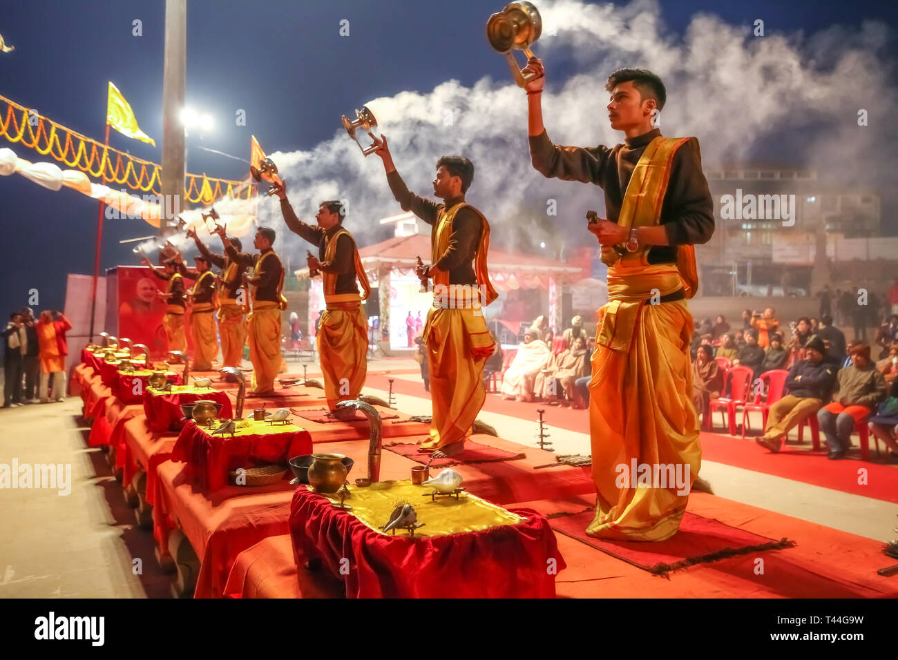 Jungen Hindu Priester führen traditionelle Ganga Aarti Zeremonie Rituale mit Feuer vor Sonnenaufgang auf dem Ganges in Varanasi, Indien. Stockfoto