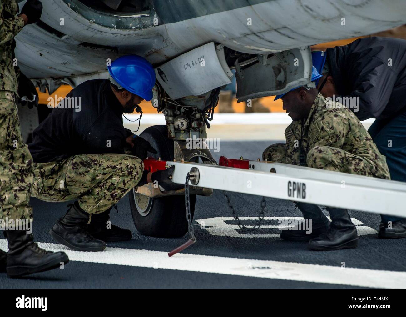 SAN DIEGO (Feb. 20, 2019) der Luftfahrt Bootsmann Mate (Handling) Airman Abb. Kennedy, Links, und der Luftfahrt Bootsmann Mate (Handling) 3. Klasse Austin Washington verbinden Sie ein Flugzeug Abschleppstange ein AV-8A Harrier an Bord der Amphibisches Schiff USS Makin Island (LHD8). Seefahrer brachten die Flugzeuge an Bord für das kommende damage control Training. Makin Island, in San Diego homeported, ist die Durchführung einer Depot Instandhaltung Verfügbarkeit. Stockfoto