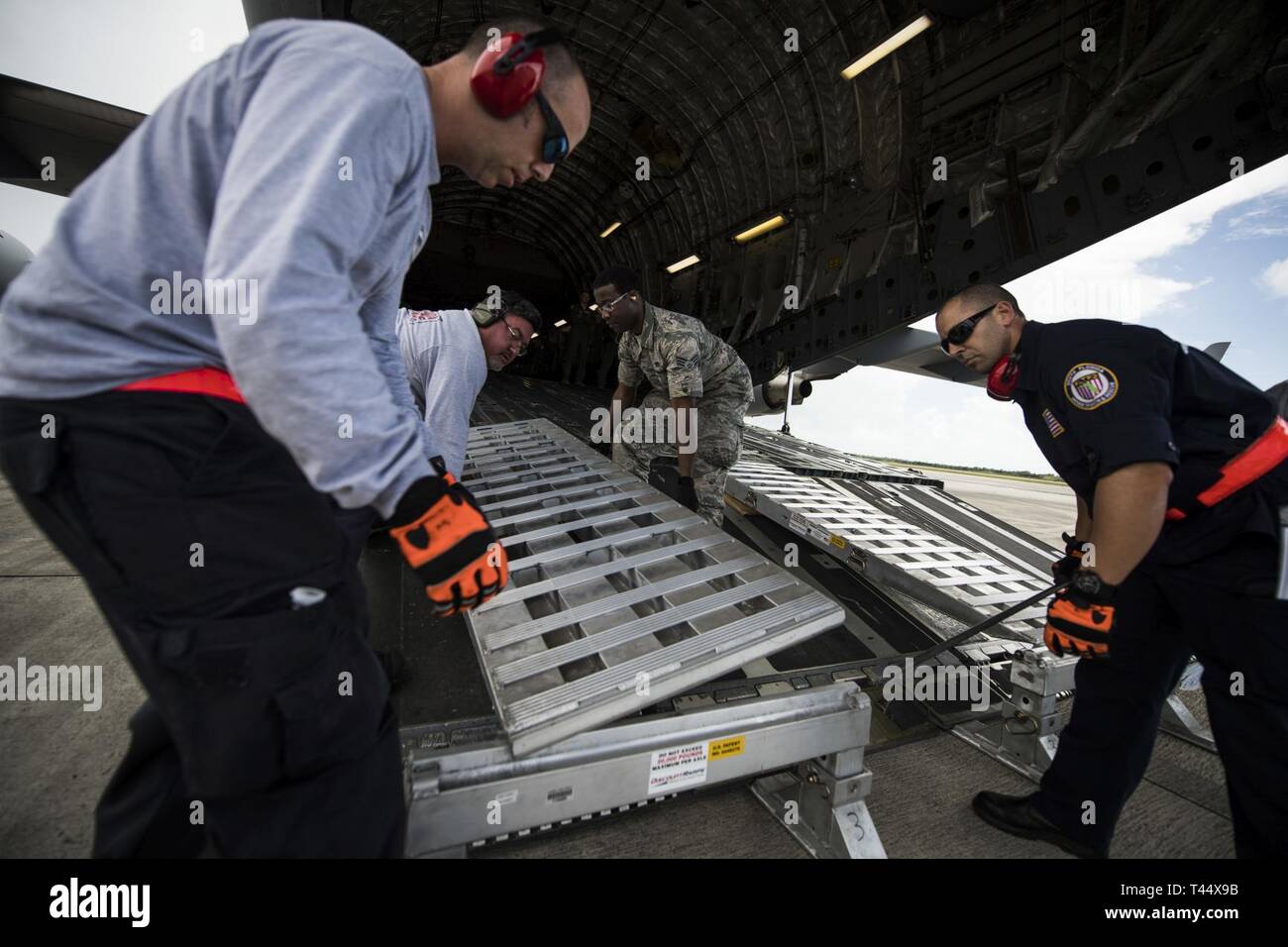 Senior Airman Kebar Morgan, rechts, eine Antenne Porter am 38. Antenne Anschluss Squadron, Joint Base Charleston, S.C. zugeordnet ist, unterstützt die Mitglieder des Südflorida Urban Such- und Rettungsteam, installieren Sie Rampen für die C-17 Globemaster III, zum Hochladen von Fahrzeugen während der Übung Patriot Sands, Homestead Air Reserve Base, Fla., Nov. 23, 2019. Übung Patriot Sands ist ein gemeinsamer Service von der Air Force Reserve, die Ersthelfer des Bundes, der Länder, der Staat, die lokalen Agenturen zu integrieren und das Militär durch die Bereitstellung eines schnellen Antwort Ausbildung im Falle eines regionalen Notfall oder natürlichen koordiniert Stockfoto