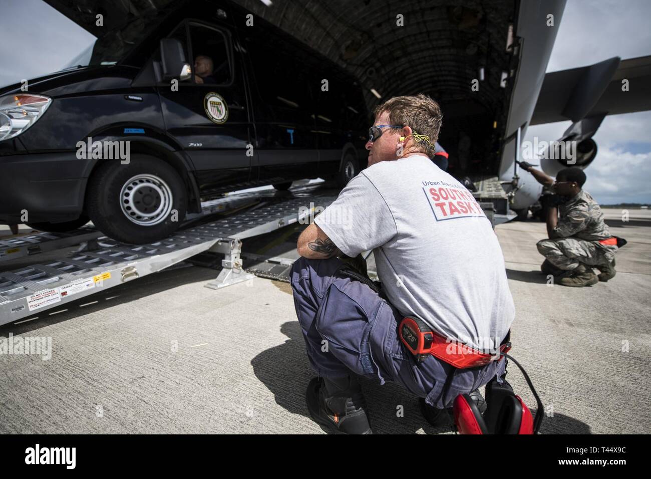 Ein Mitglied der South Florida Urban Such- und Rettungsteam, beobachtet eine Fahrt auf einem C-17 Globemaster III, während der Übung Patriot Sands, Homestead Air Reserve Base, Fla., Nov. 23, 2019. Übung Patriot Sands ist ein gemeinsamer Service von der Air Force Reserve, die Ersthelfer des Bundes, der Länder, der Staat, die lokalen Agenturen zu integrieren und das Militär durch die Bereitstellung eines schnellen Antwort Ausbildung im Falle eines regionalen Notfall oder Naturkatastrophe koordiniert. Stockfoto