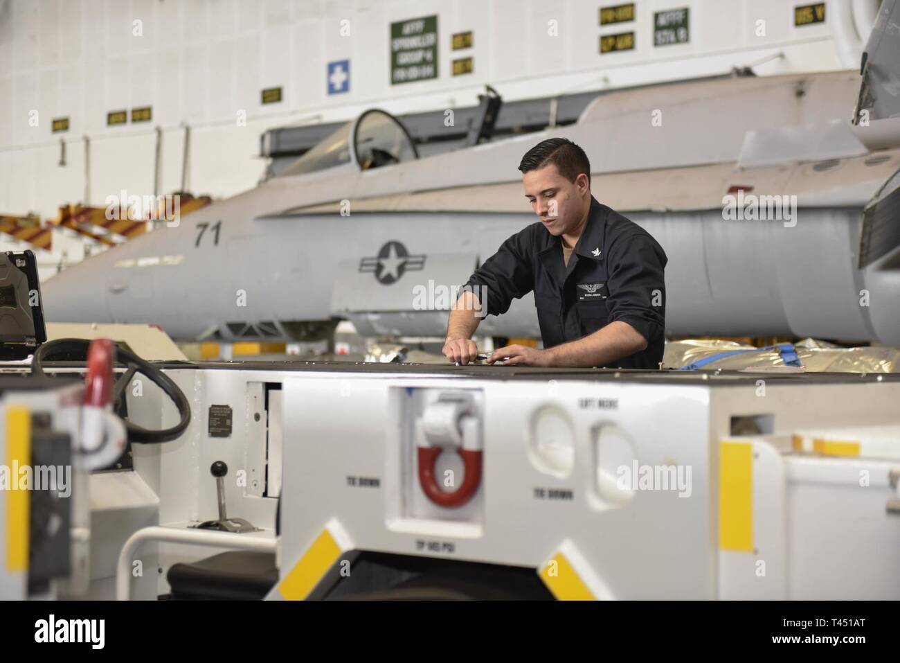 Pazifik (Feb. 26, 2019) Aviation Support Equipment Techniker 3. Klasse Josua Rivera, von Orlando, Fla., befestigt, eine Schraube auf einer Spotting dolly im Hangar Bucht der Flugzeugträger USS Theodore Roosevelt (CVN 71). Theodore Roosevelt ist die Durchführung von Routineaufgaben im östlichen Pazifik. Stockfoto