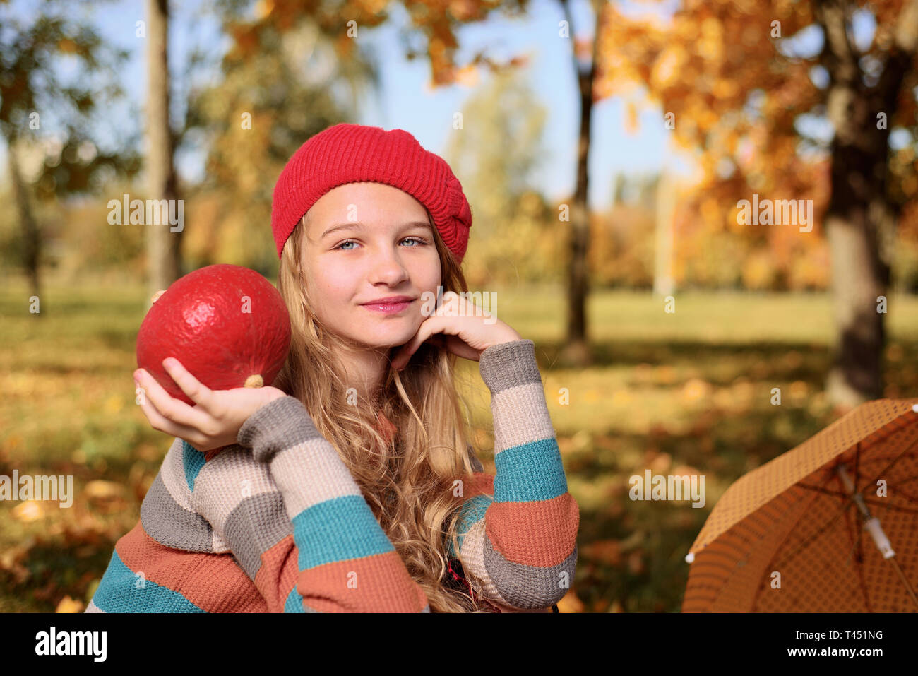 Herbst Porträt der schönen jungen Mädchen. ein Teenager in Red Hat lächelt und halten Helle reife Kürbis. Stockfoto