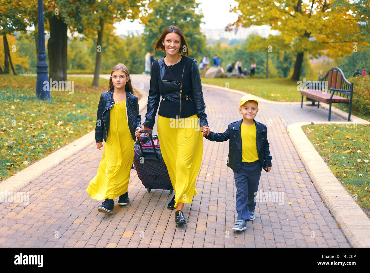 Glückliche Familie lächelnd. Mutter, Tochter und Sohn in Urlaub gehen, mit Koffer Stockfoto