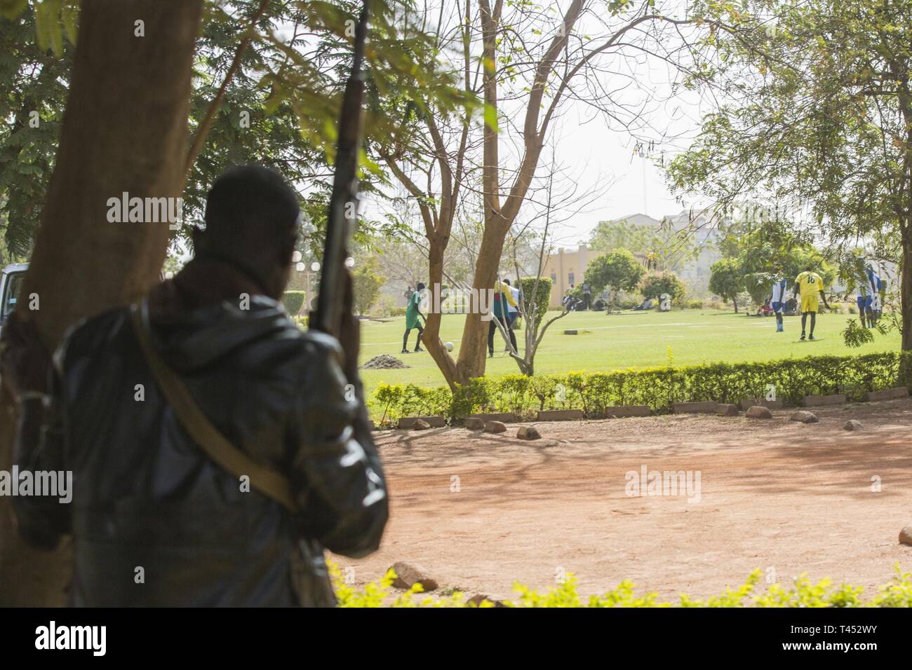 Einen Terroristen sieht auf seine potentiellen Opfer während eines simulierten Terroranschlag in Ouagadougou, Burkina Faso am 13.02.27., 2019. Eine große Kraft von Terroristen angegriffen, die Spieler mit AK-47 Gewehre während der Übung Flintlock 2019. Stockfoto