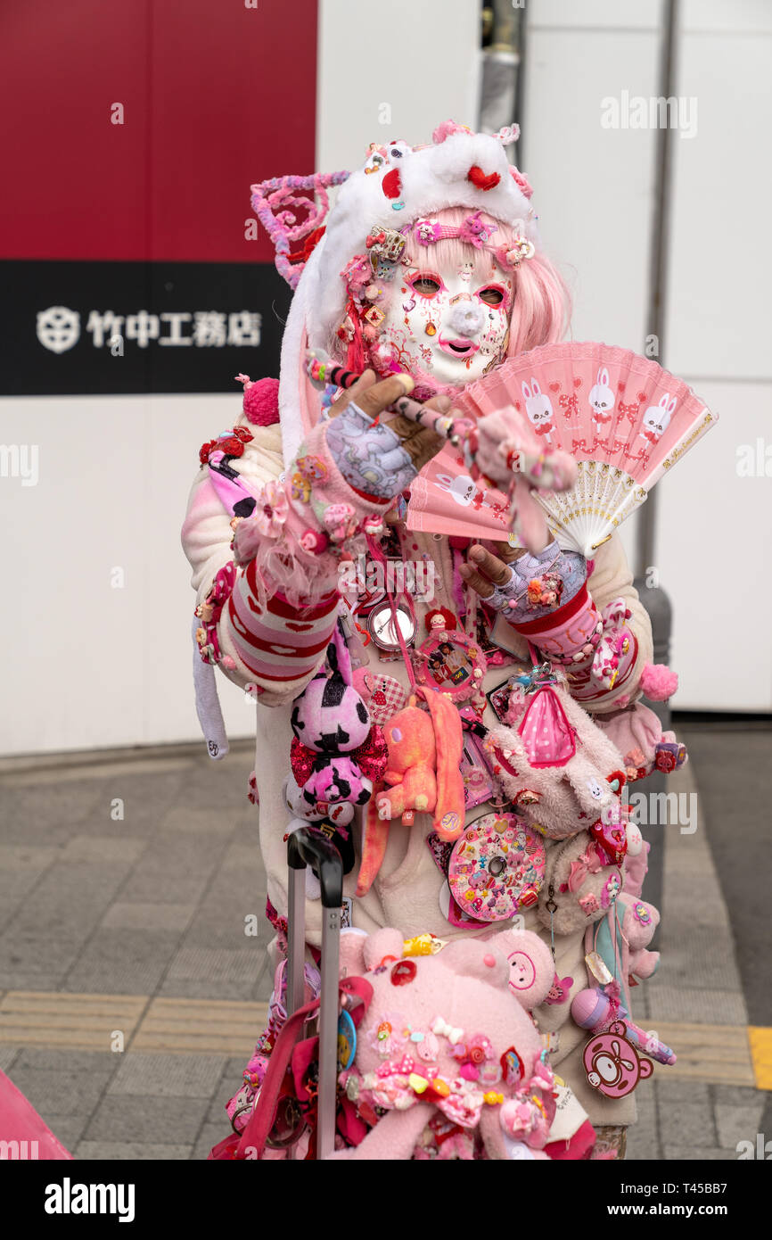 Tokio, Harajuku ist der Cos-Spielen von Tokio, mit verschiedenen junge Mode im Beweis. Dieser Mann, bekannt als Kadocchi, als er unoffical Symbol von Harajuku betrachtet. Mann verkleidet als Clown in rosa und weißen Outfit und hält das Gebläse, für den Betrachter darstellen. Auge - Kontakt. Stockfoto