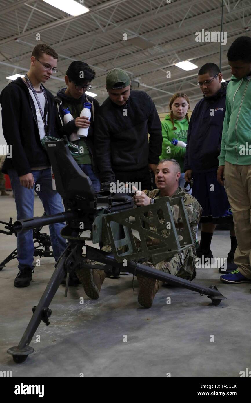 RAEFORD, N.C. - North Carolina National Guard Staff Sgt. Anthony Faso, zu der 105 Ingenieur Bataillon zugeordnet, Hands-on Training eines Mk19 Granatwerfer und anderen Waffen zu High School Studenten aus Raeford und südlichen Regionen von NC während des NCNG Guard X Challenge am 13.02.23., 2019. Dies ist der erste Guard X event Partnerschaften lokale Guard line-Einheiten, wie der 105 Ingenieur Bataillon mit NCNG Recruiting und Retention. Stockfoto