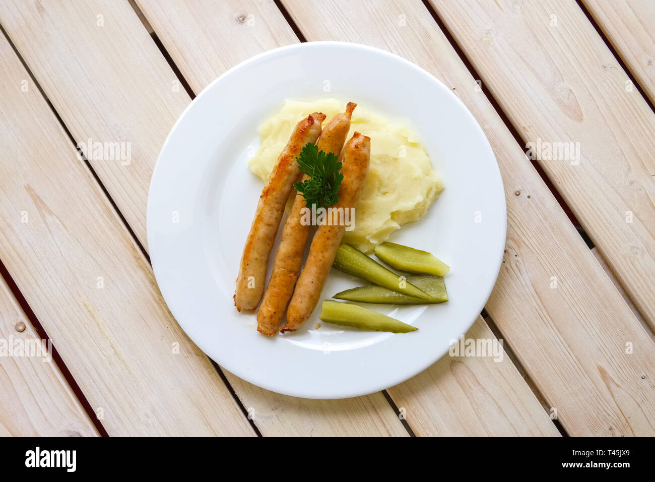 Bratwurst mit Kartoffelpüree und Gurken Stockfoto