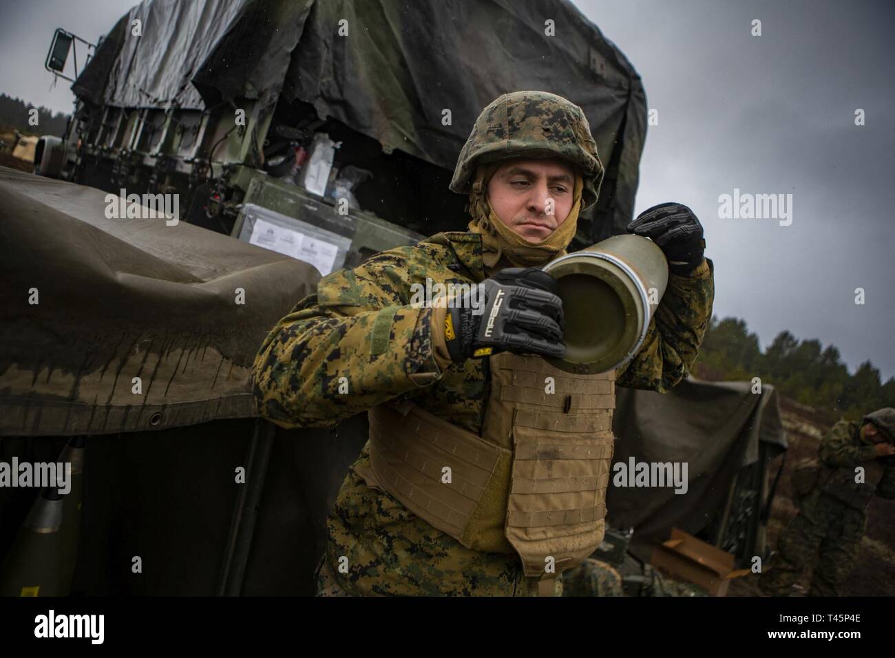 Us Marine Corps Cpl. John R. Garbo, ein cannoneer mit Hotel, 3. Batterie Bataillon, 14 Marine Regiment, 4 Marine Division, trägt ein M795 155 mm Projektil über seine Schulter zu Adazi, Lettland, 5. März 2019, zur Unterstützung der Übung Dynamische Front 19. Übung Dynamische Front 19 umfasst ca. 3.200 Mitglieder aus 27 Nationen, die zu beobachten sind oder die Teilnahme von grafenwöhr Training Area, Deutschland; Riga, Lettland; und Torun, Polen; im März 2-9, 2019. Dynamische Vordere ist eine jährliche US-Army Europe Übung konzentriert sich auf die Bereitschaft und die Interoperabilität der US-Armee, Stockfoto