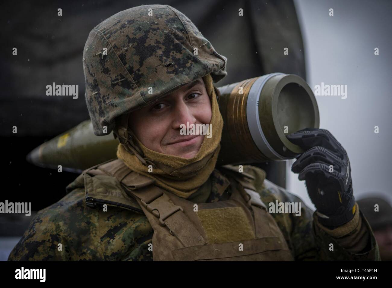 Us Marine Corps Cpl. John R. Garbo, ein cannoneer mit Hotel, 3. Batterie Bataillon, 14 Marine Regiment, 4 Marine Division, trägt ein M795 155 mm Projektil über seine Schulter zu Adazi, Lettland, 5. März 2019, zur Unterstützung der Übung Dynamische Front 19. Übung Dynamische Front 19 umfasst ca. 3.200 Mitglieder aus 27 Nationen, die zu beobachten sind oder die Teilnahme von grafenwöhr Training Area, Deutschland; Riga, Lettland; und Torun, Polen; im März 2-9, 2019. Dynamische Vordere ist eine jährliche US-Army Europe Übung konzentriert sich auf die Bereitschaft und die Interoperabilität der US-Armee, Stockfoto