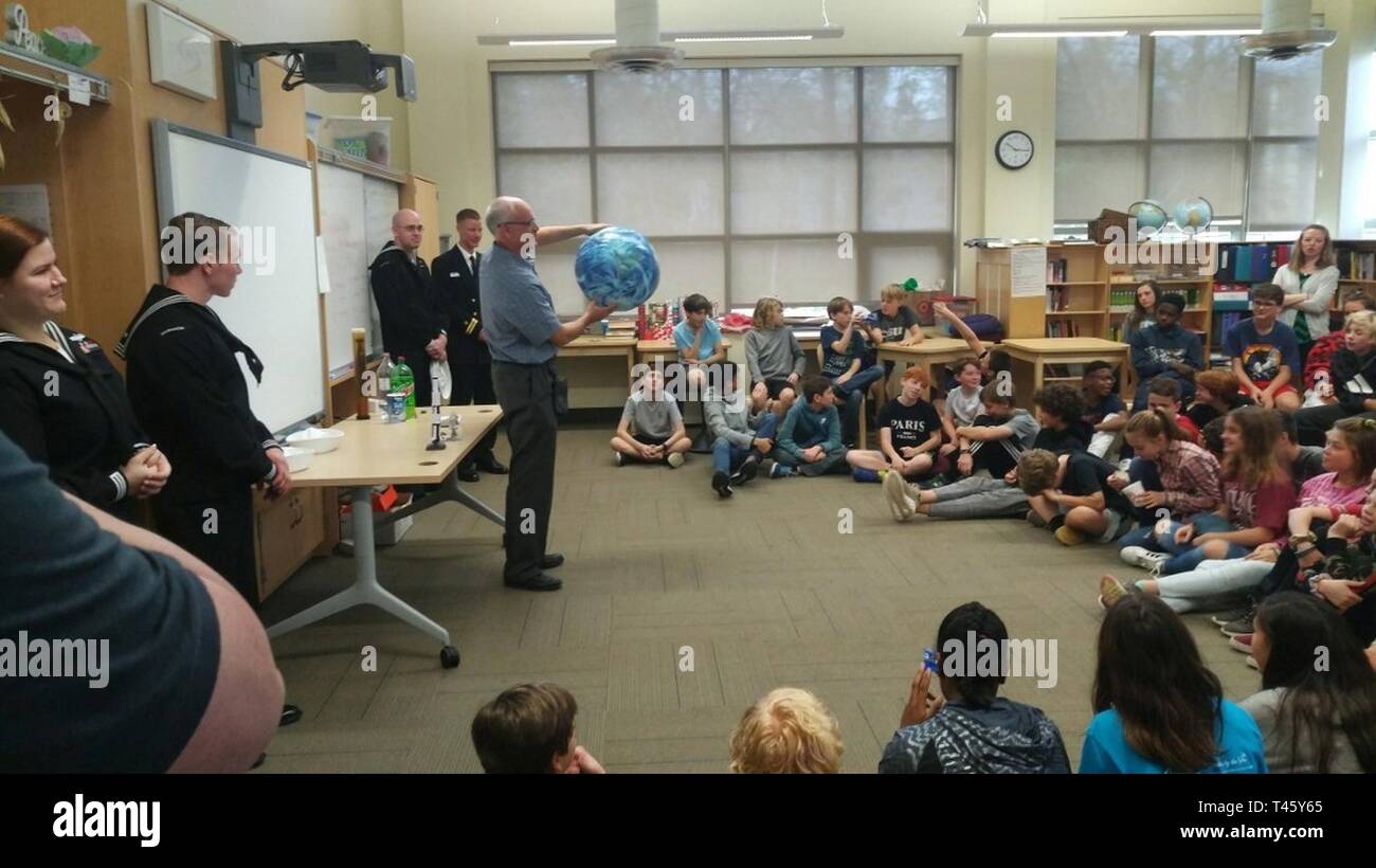 CHARLESTON, S.C. (11. März 2019) Jim Vermeulen, der Naval Meteorologie und Ozeanographie Befehl, spricht mit Studenten aus Montessori Gemeinschaft Schule auf verschiedene Arten von Satelliten. Die Marine Woche Programm als Principal übertreffen Bemühung der Marine in den Bereichen des Landes ohne eine bedeutende Marine Anwesenheit dient. Stockfoto