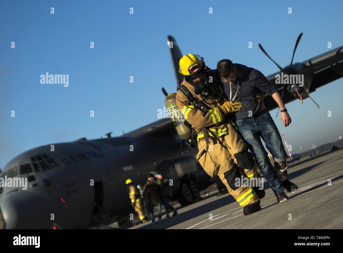Ein 86Th Bauingenieur Squadron Feuerwehrmann hilft eine simulierte Flugzeugabsturz Opfer während der Übung Operation Varsity 08-07 auf der Air Base Ramstein, Deutschland, Feb.27, 2019. Ramstein für Rettungskräfte wurden auf ihre Fähigkeit, eine große Katastrophe zu reagieren getestet. Stockfoto