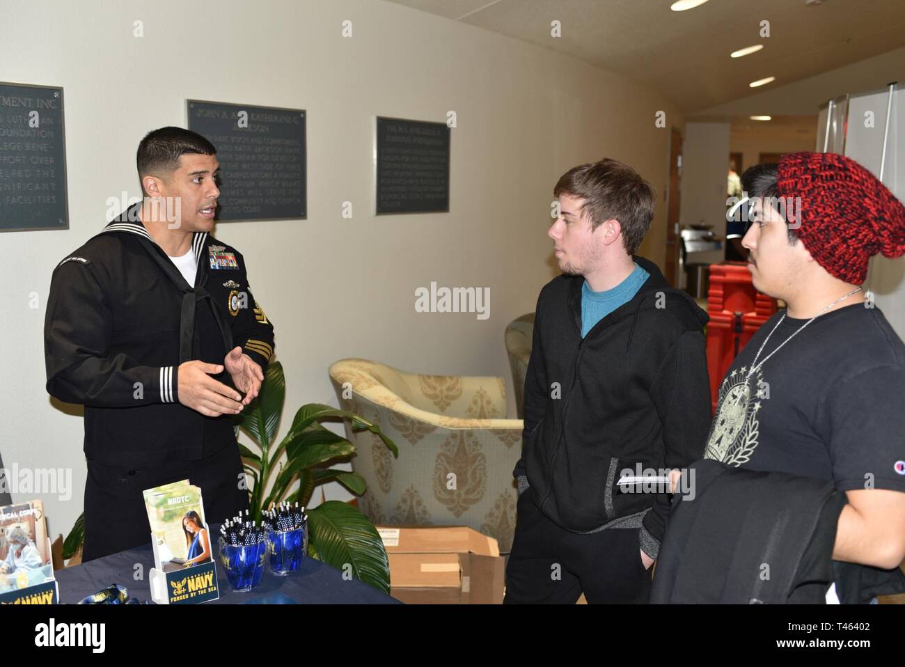 SEGUIN, Texas (1. März 2019) Navy Ratgeber 1. Klasse Jose Zouain (links) von See Mary, Fla., zum Navy Recruiting Station (NRS) San Marcos zugeordnet, spricht mit den Teilnehmern über Möglichkeiten in Amerikas Marine während der US Navy Band Konzert in der Jackson Auditorium auf dem Campus der Texas Lutheran University. Nach seinem Studium an der See Mary High School, Zouain trat Amerikas Marine im Jahr 2005 immer ein personalvermittler im Jahr 2011. Die US-Marine Band in 10 Staaten während seiner 23-Stadt, 5.000 km langen Tour, verbinden die Gemeinschaften über die Nation ihre Marine. Die Tour dient das Publikum mit ent Stockfoto