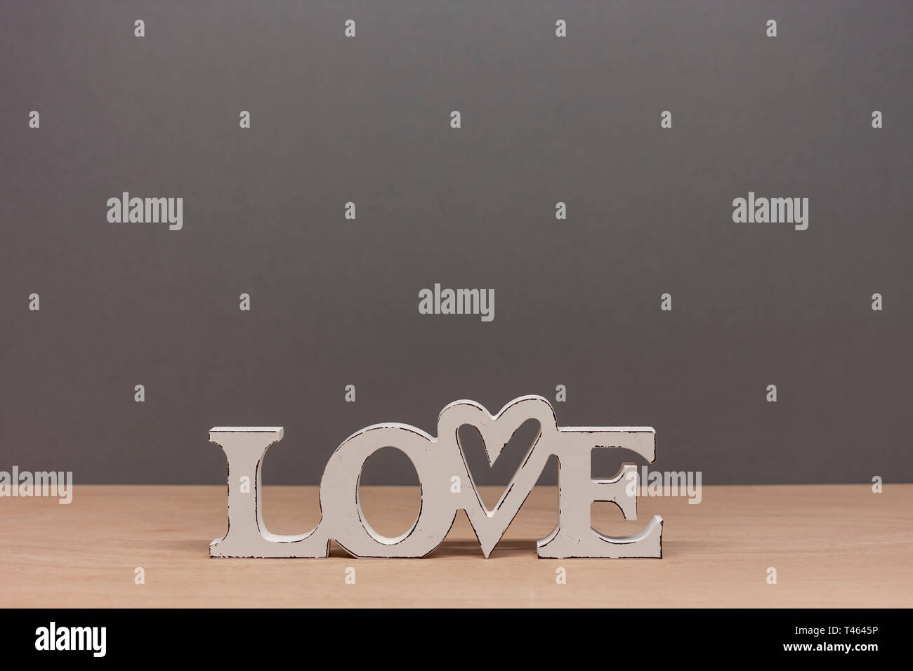 Holz- Wort Liebe auf grauem Papier Hintergrund Stockfoto