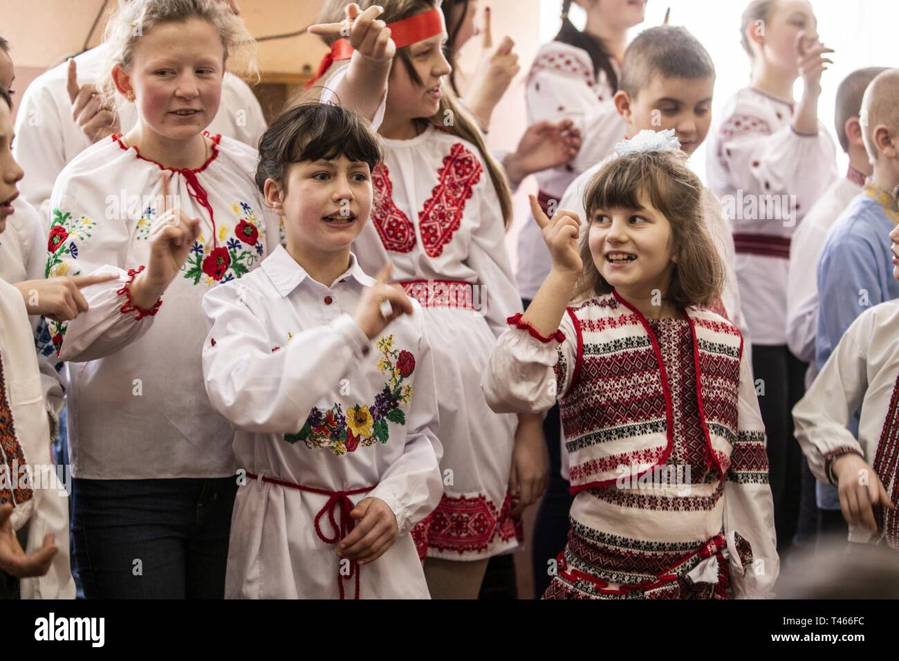 Studenten aus dem Rehabilitationszentrum für Kinder mit besonderen Bedürfnissen singen zu multinationalen Soldaten bei einem Besuch im Waisenhaus in Krakovets, Ukraine, März 4. Stockfoto