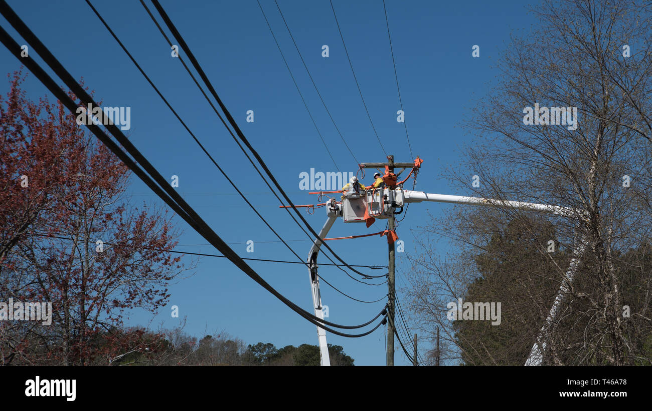 Männer im Eimer auf erweiterten Cherry Picker Instandsetzung der elektrischen Kabel Stockfoto