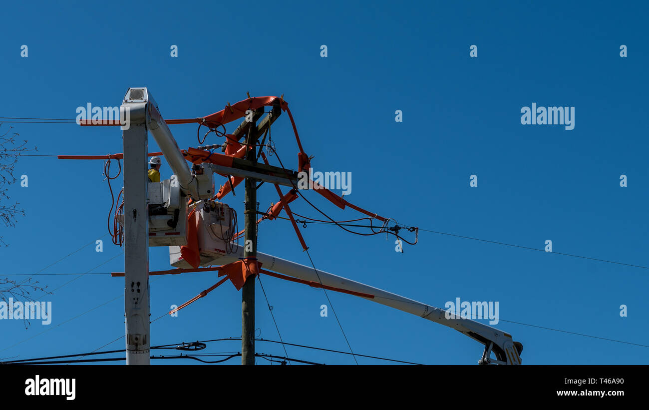 Männer im Eimer auf erweiterten Cherry Picker Instandsetzung der elektrischen Kabel Stockfoto
