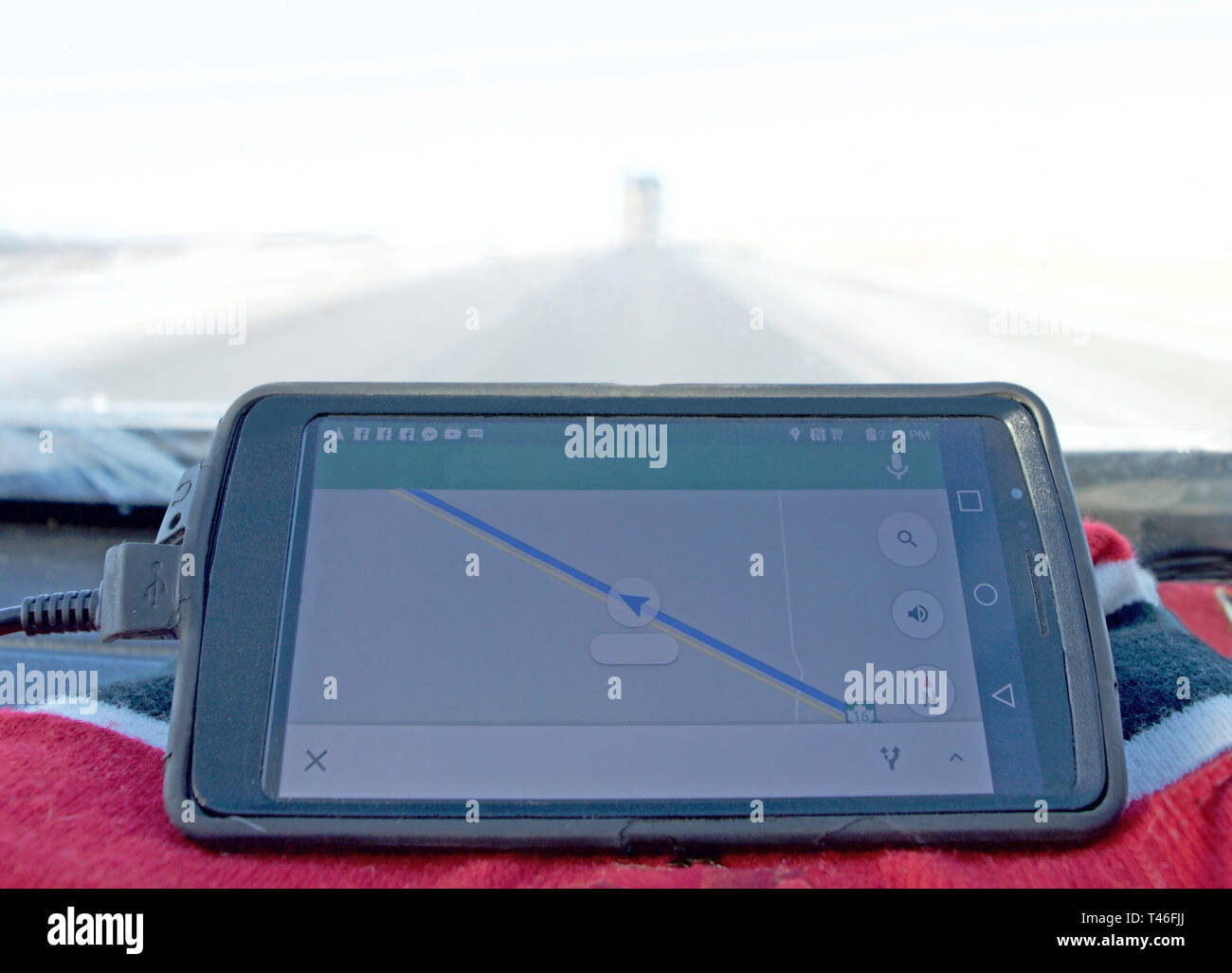 GPS-Gerät auf dem Armaturenbrett eines Autos im Nebel und Blizzard. Stockfoto