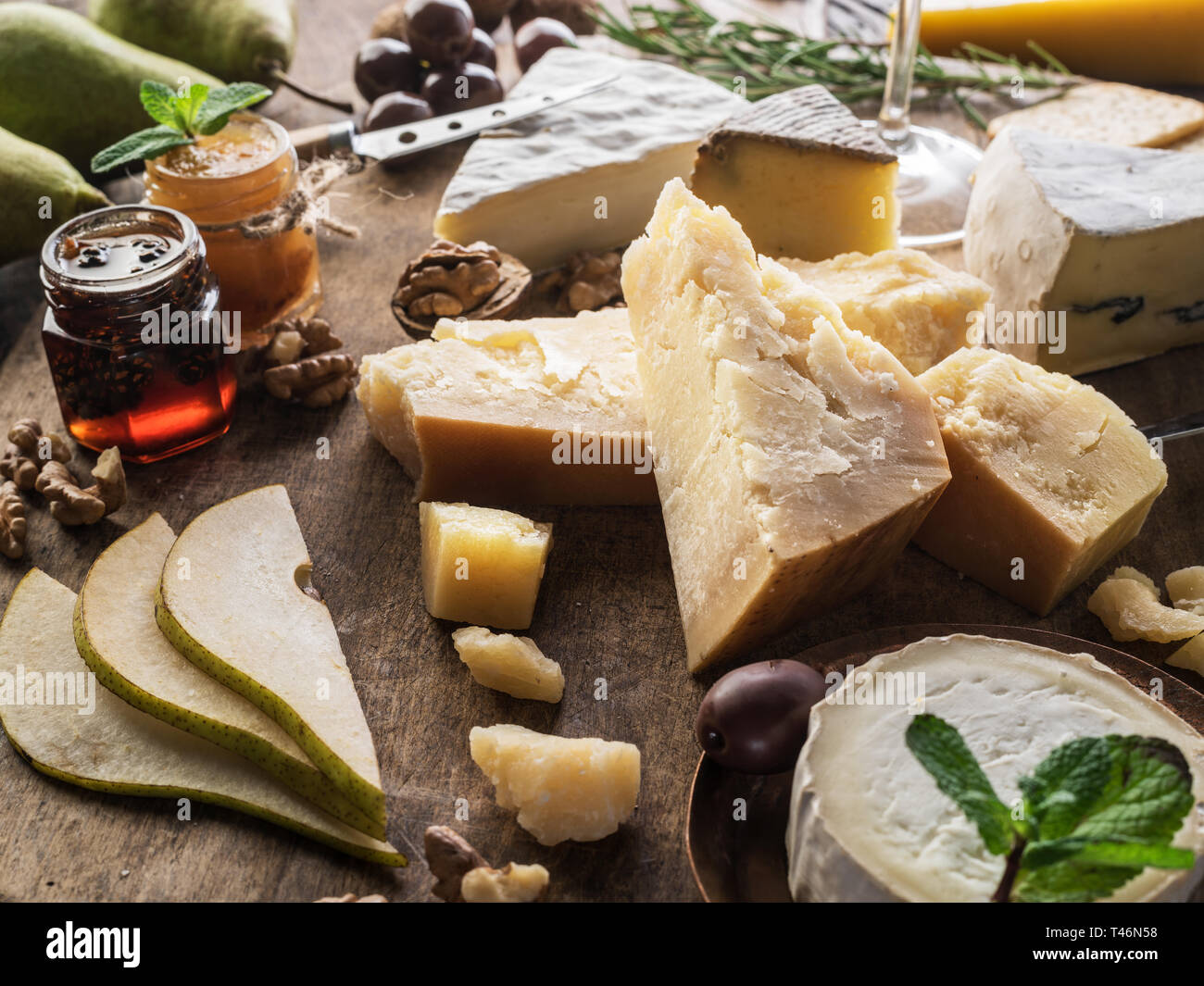 Käseplatte mit Bio Käse, Früchte und Wein auf Holz- Hintergrund. Lecker Käse Starter. Stockfoto