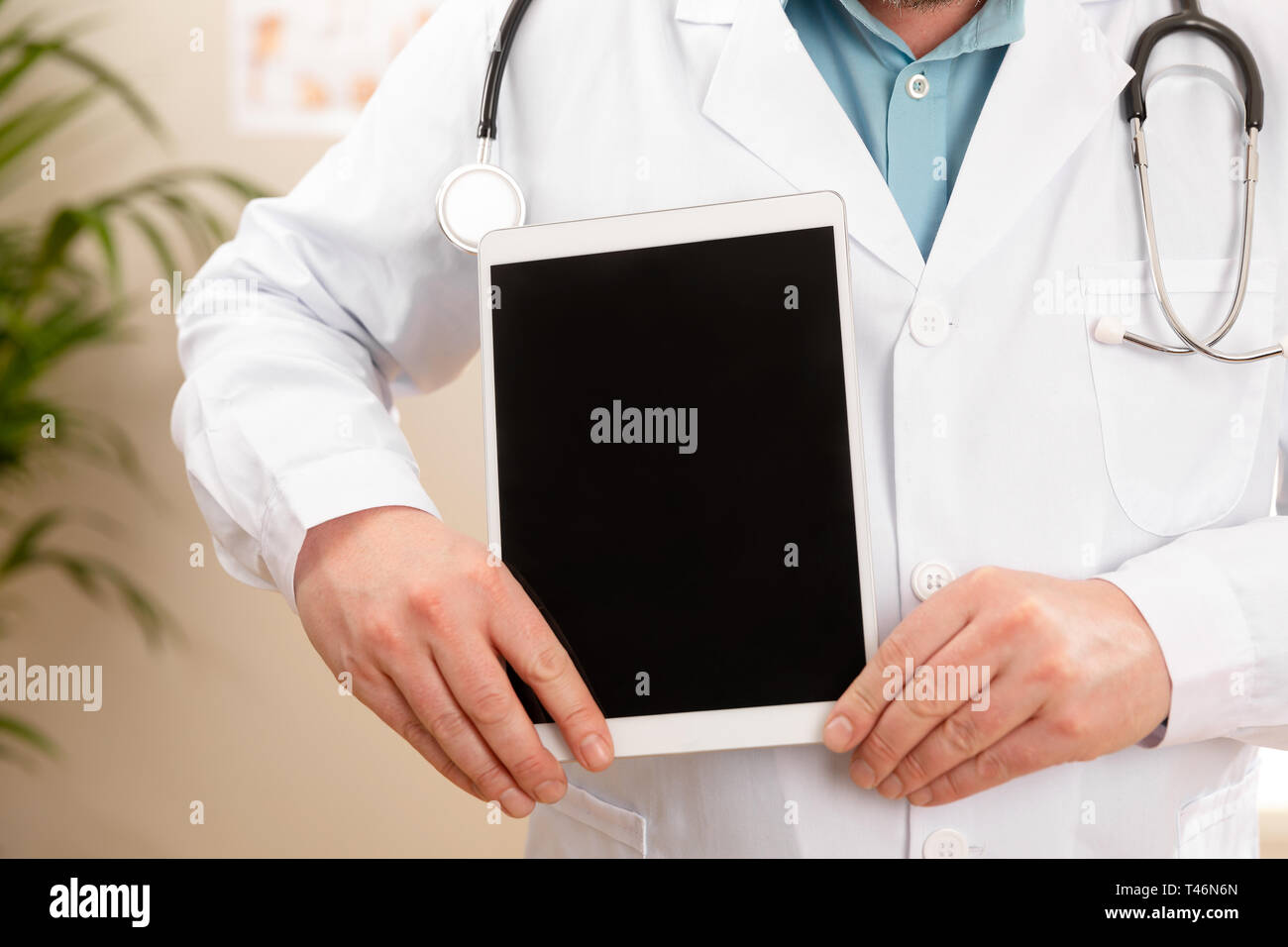 Erwachsenen männlichen Arzt zeigt ein digitales Bild oder einen Bericht über eine Tablette Stockfoto
