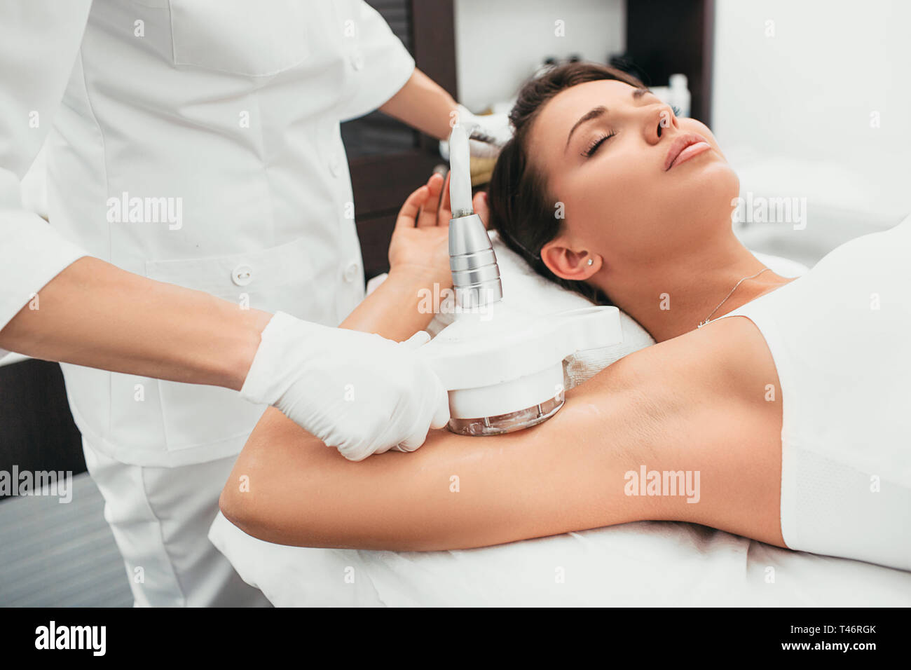 Frau erhält Anti-Cellulite-Massage, Kavitation Verfahren an Hand Stockfoto
