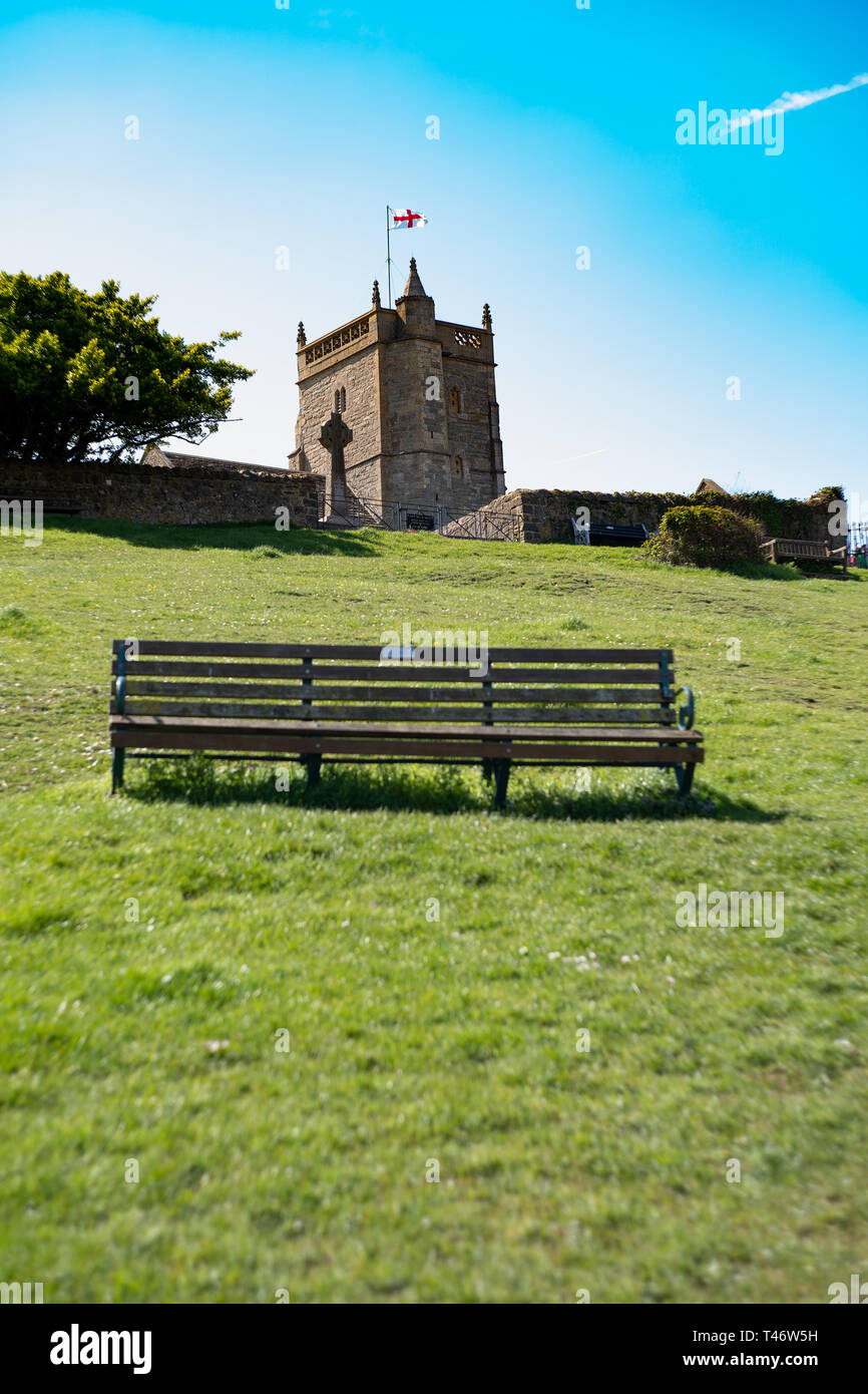 Alte Kirche des Hl. Nikolaus und eine Bank auf einem grasbewachsenen Hügel, bergauf, Weston-super-Mare, North Somerset, VEREINIGTES KÖNIGREICH Stockfoto
